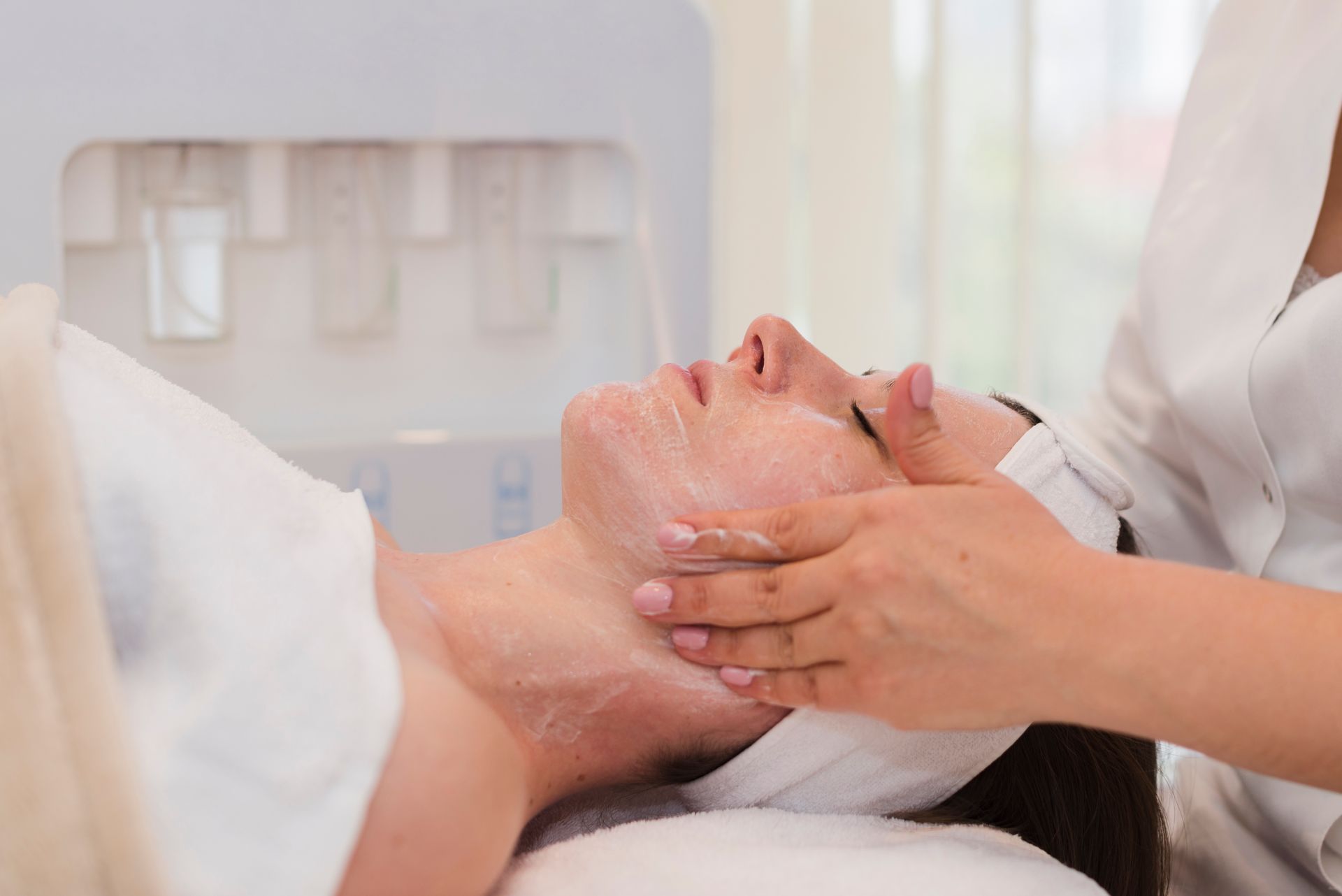 A woman is getting a facial treatment at a spa.