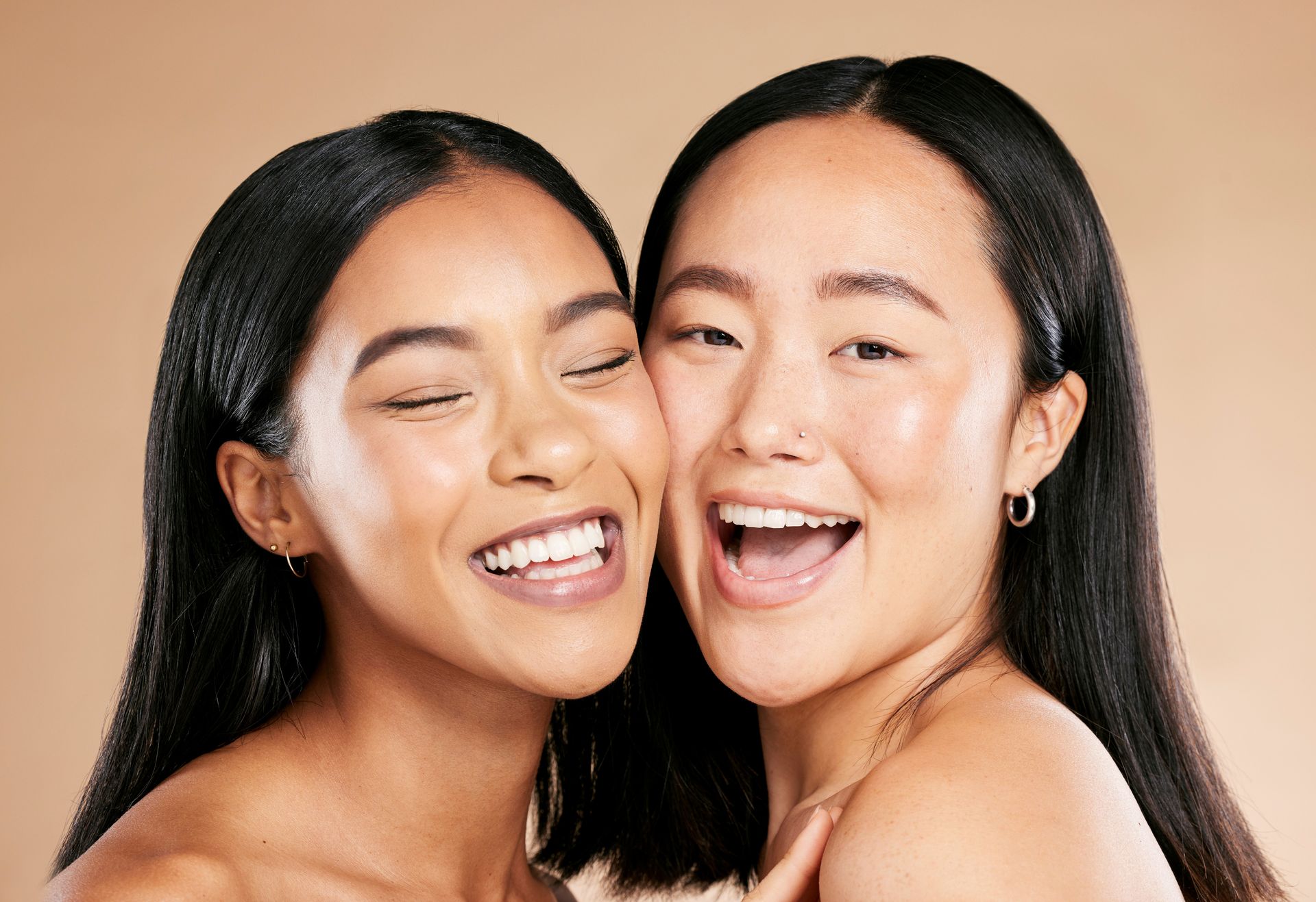 Two women are hugging each other and smiling for the camera.