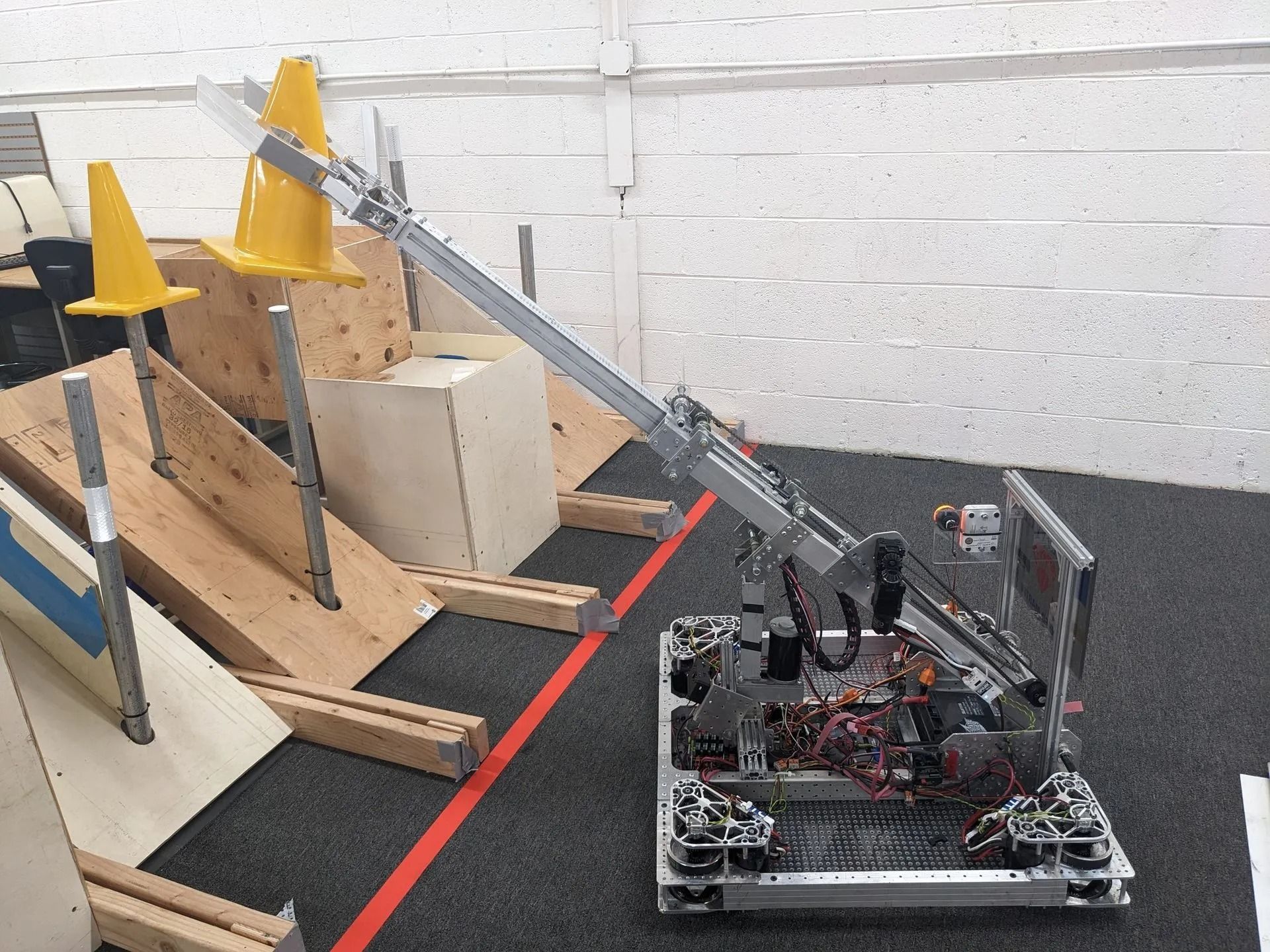 Robot with an articulated arm in a robotics competition setting, navigating an obstacle course.