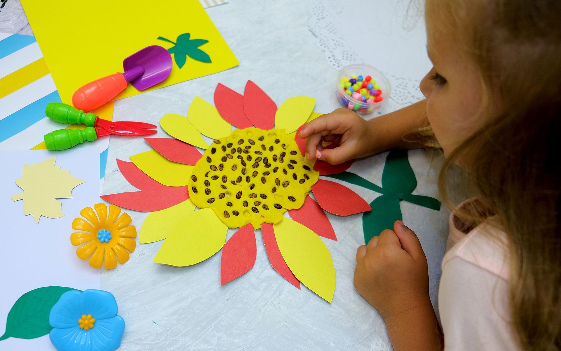 Girl making a sunflower craft. 