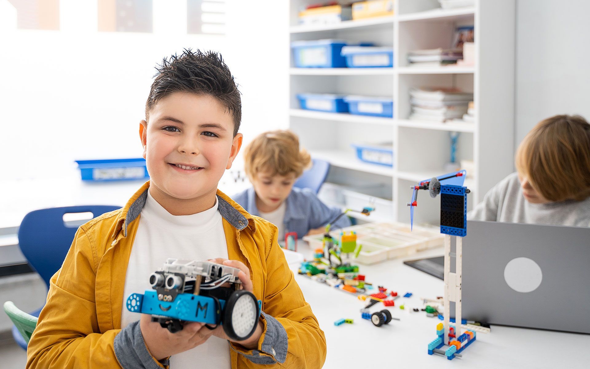 Boy holding a robot, smiling.