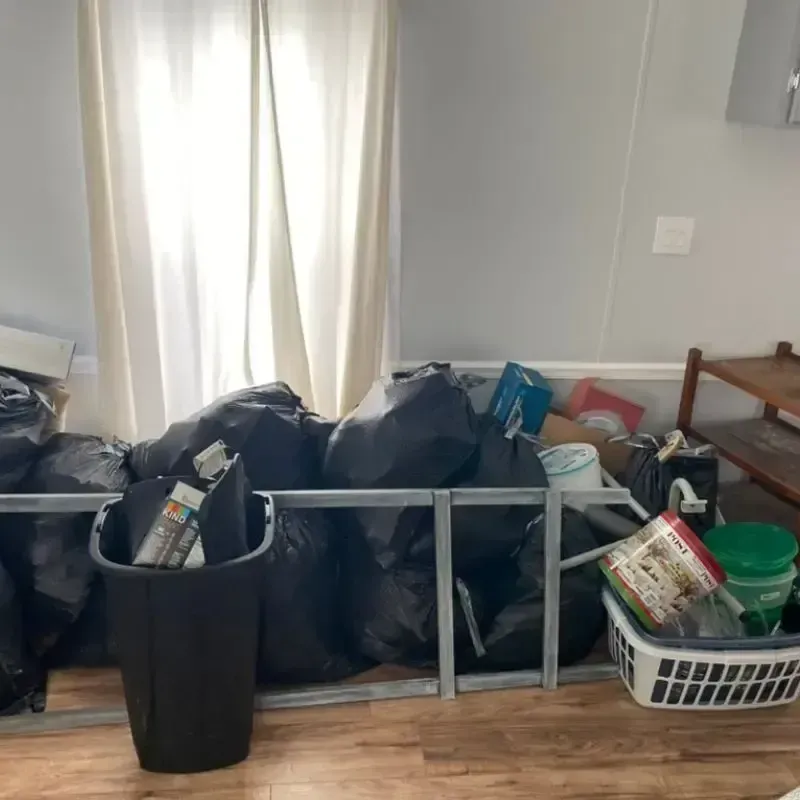 Room interior with black trash bags and a bin messy.