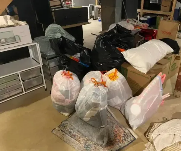 A room filled with lots of trash bags and boxes.