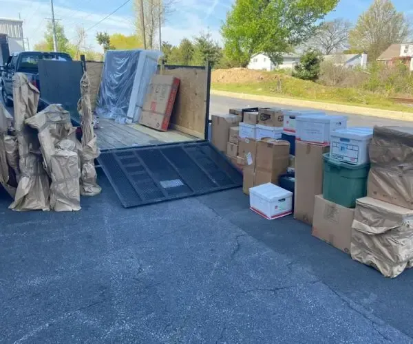 A truck full of boxes is parked on the side of the road.