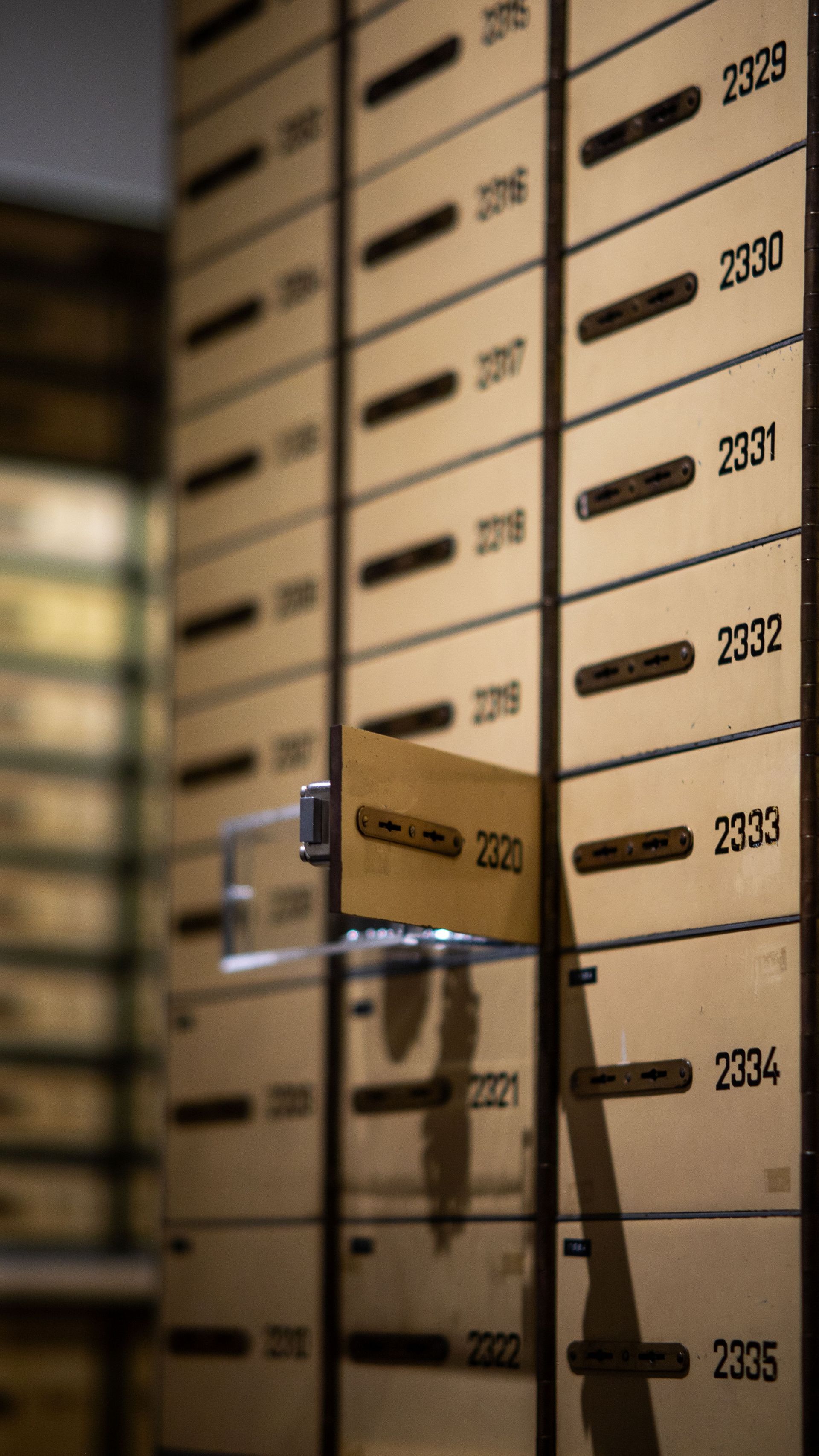 Rows of numbered cardboard boxes on warehouse shelves, with a glass door reflecting the scene.