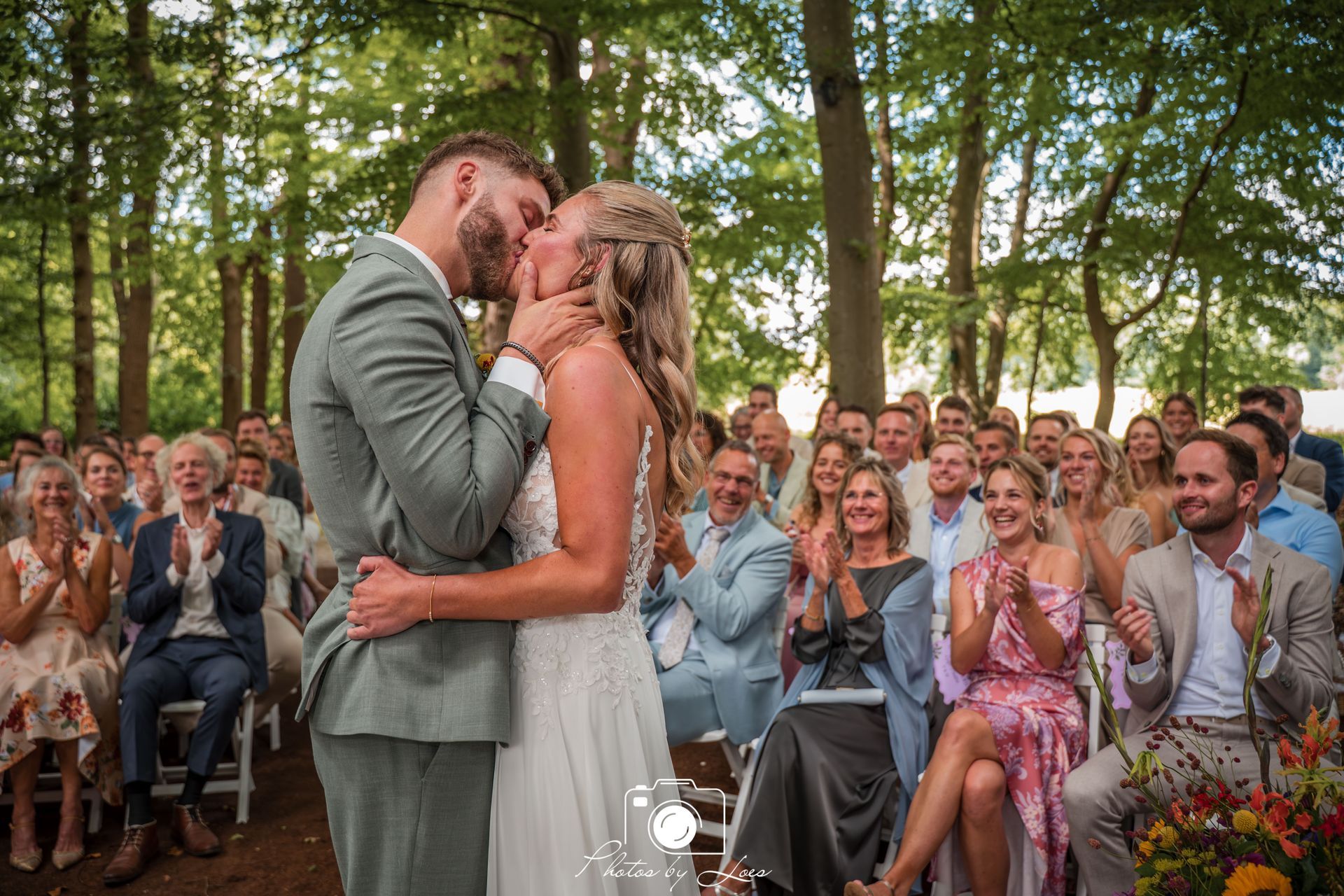 Een bruid en bruidegom dansen op het strand.
