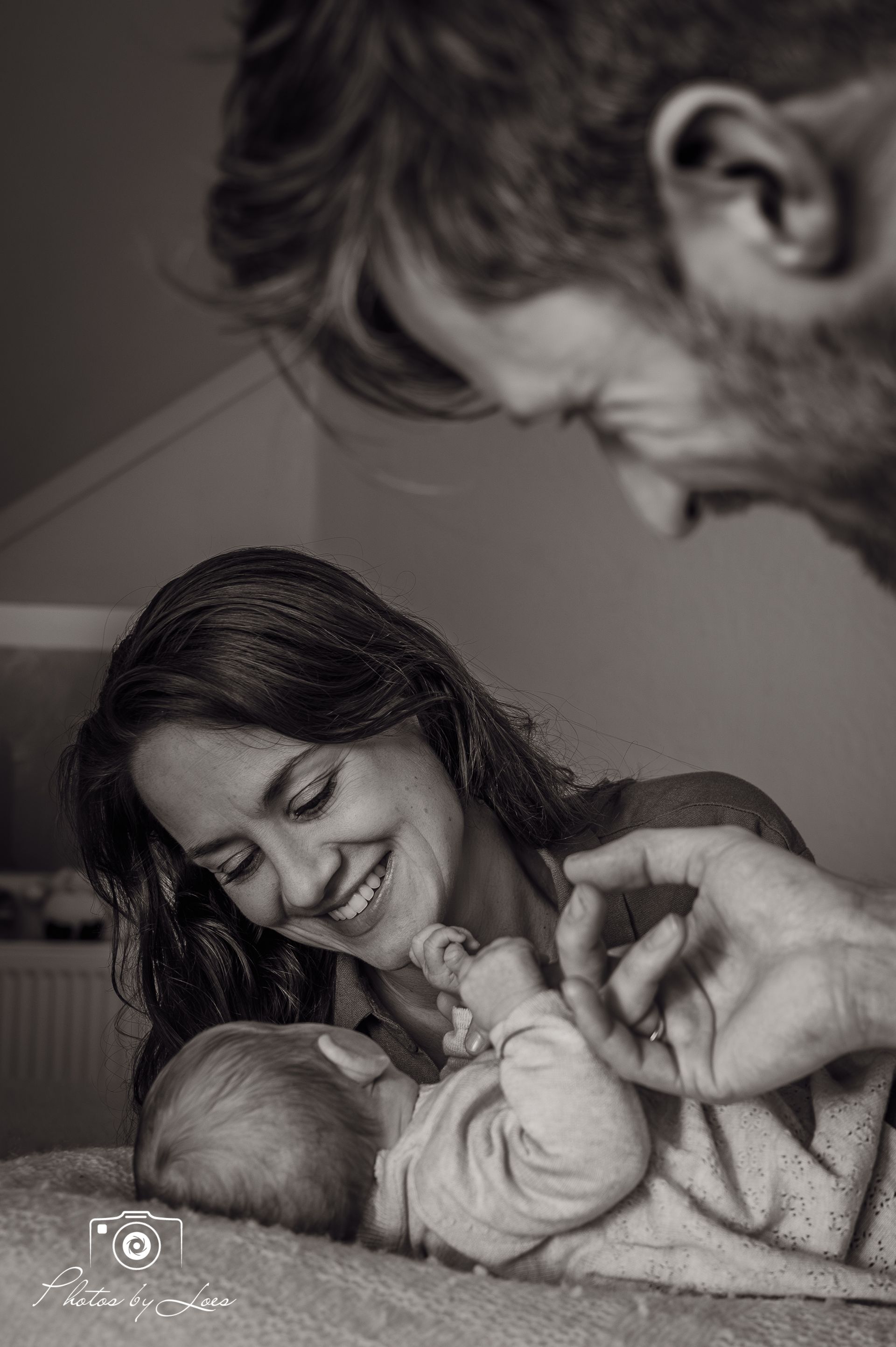 Een zwart-witfoto van een vrouw en een man die een baby vasthouden.