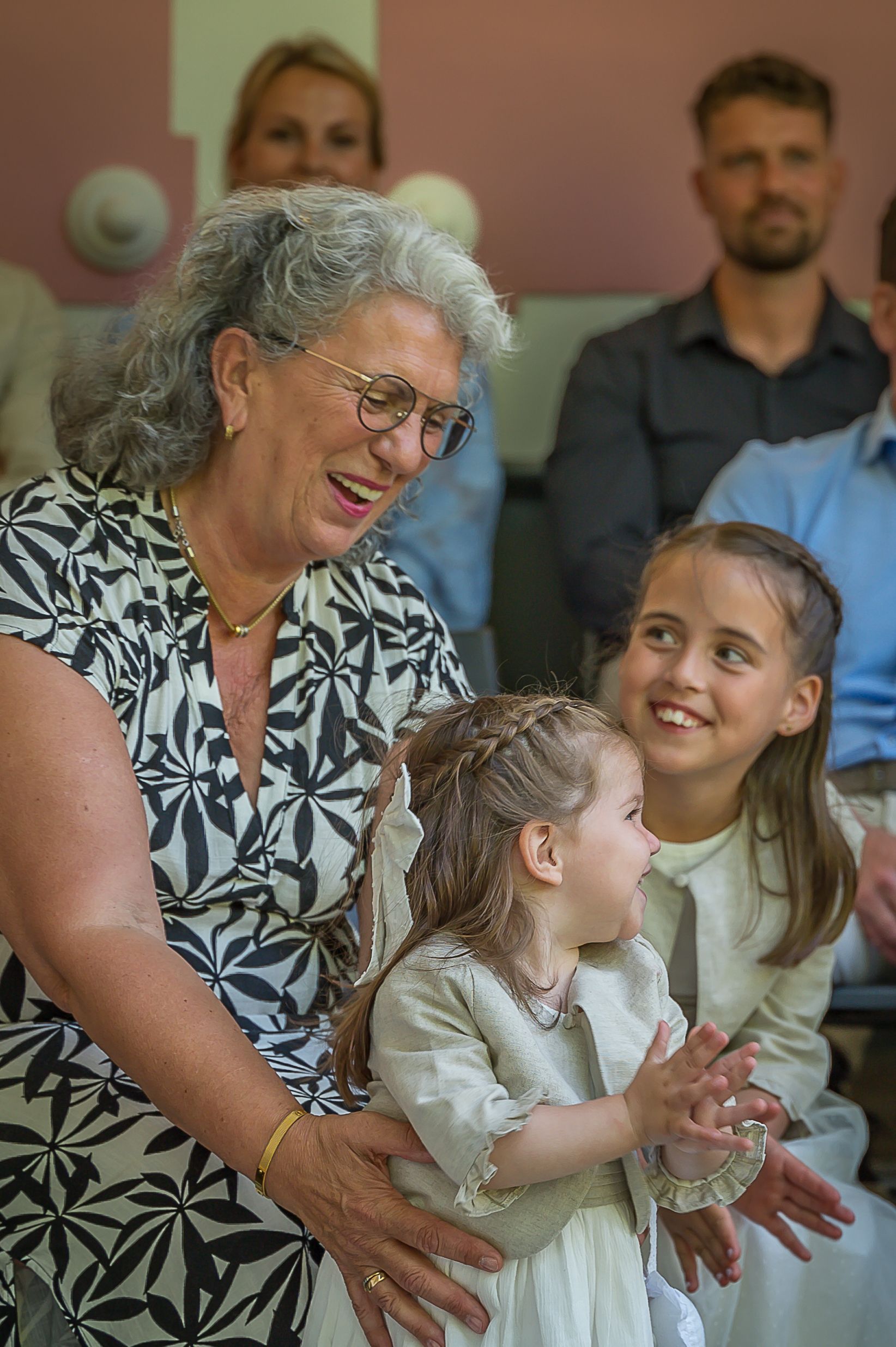 Een vrouw houdt twee kleine meisjes in haar armen.