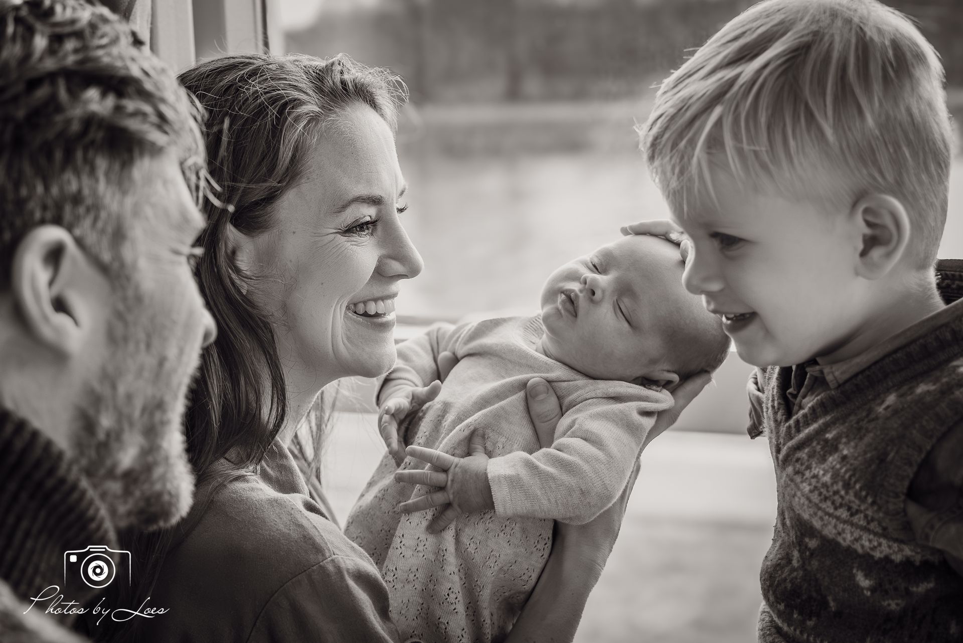 Een zwart-witfoto van een gezin dat naar elkaar kijkt.