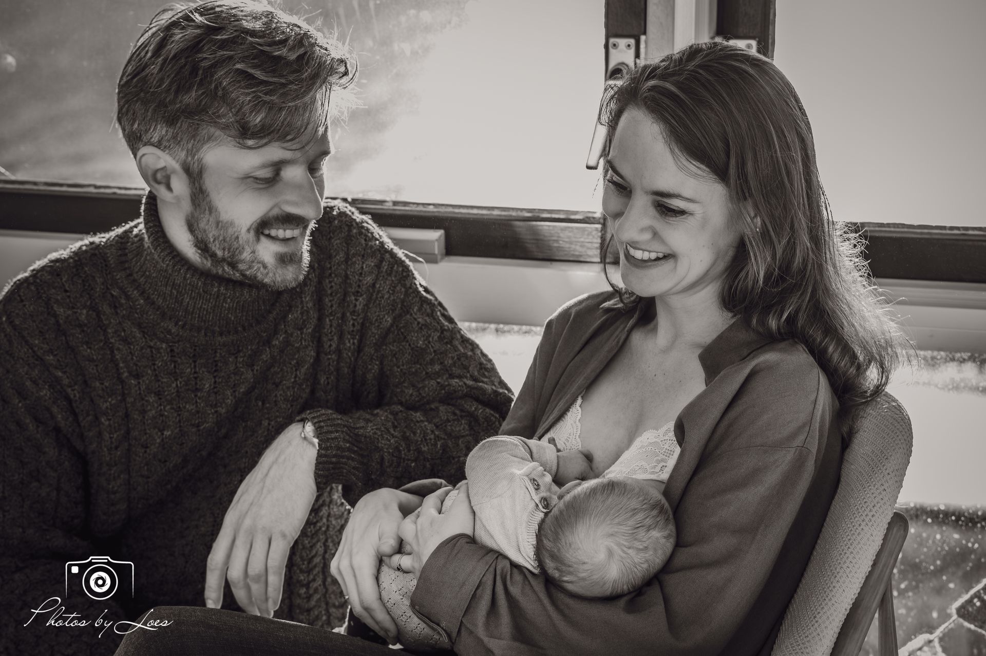 Op een zwart-witfoto houden een man en een vrouw een baby vast.