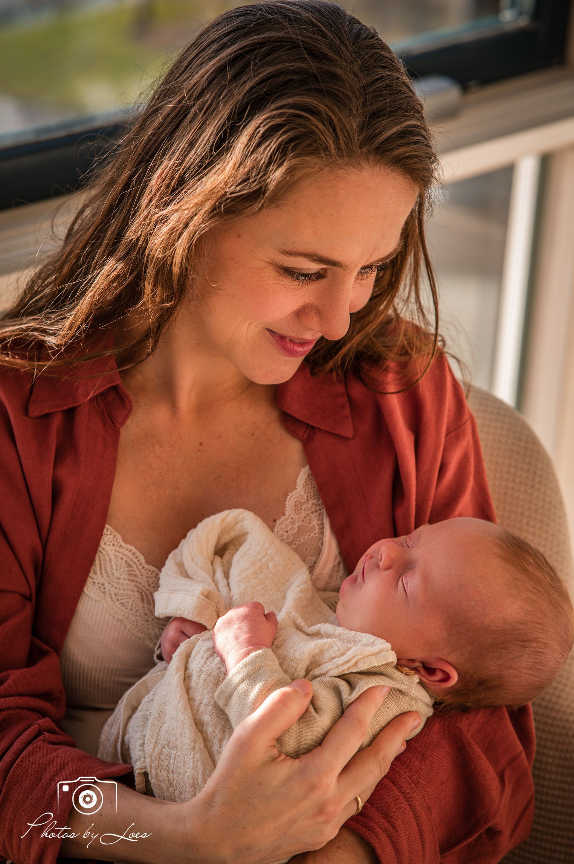 Een vrouw houdt een pasgeboren baby in haar armen.