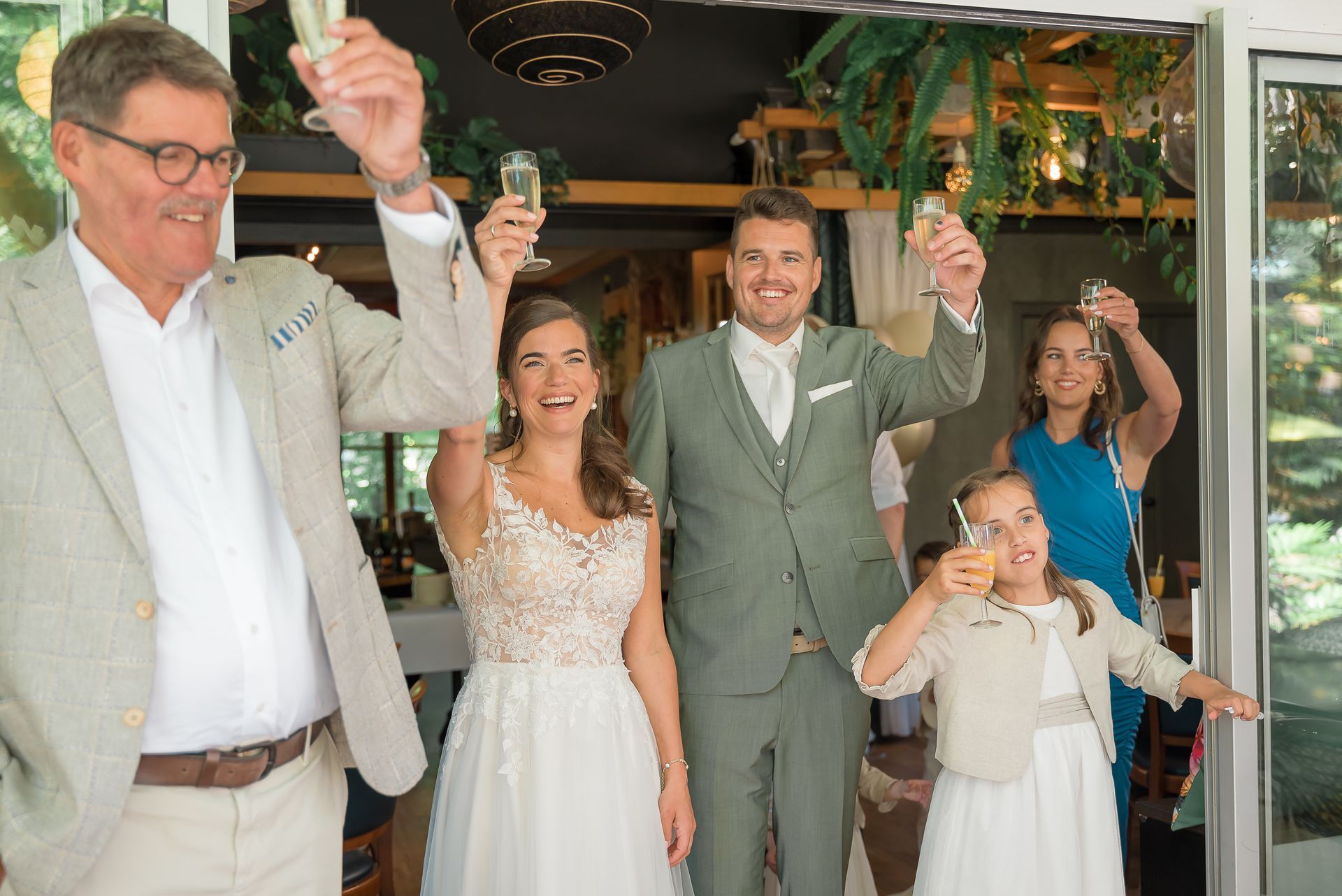 Een bruid en bruidegom toosten met hun bruiloftsgasten.