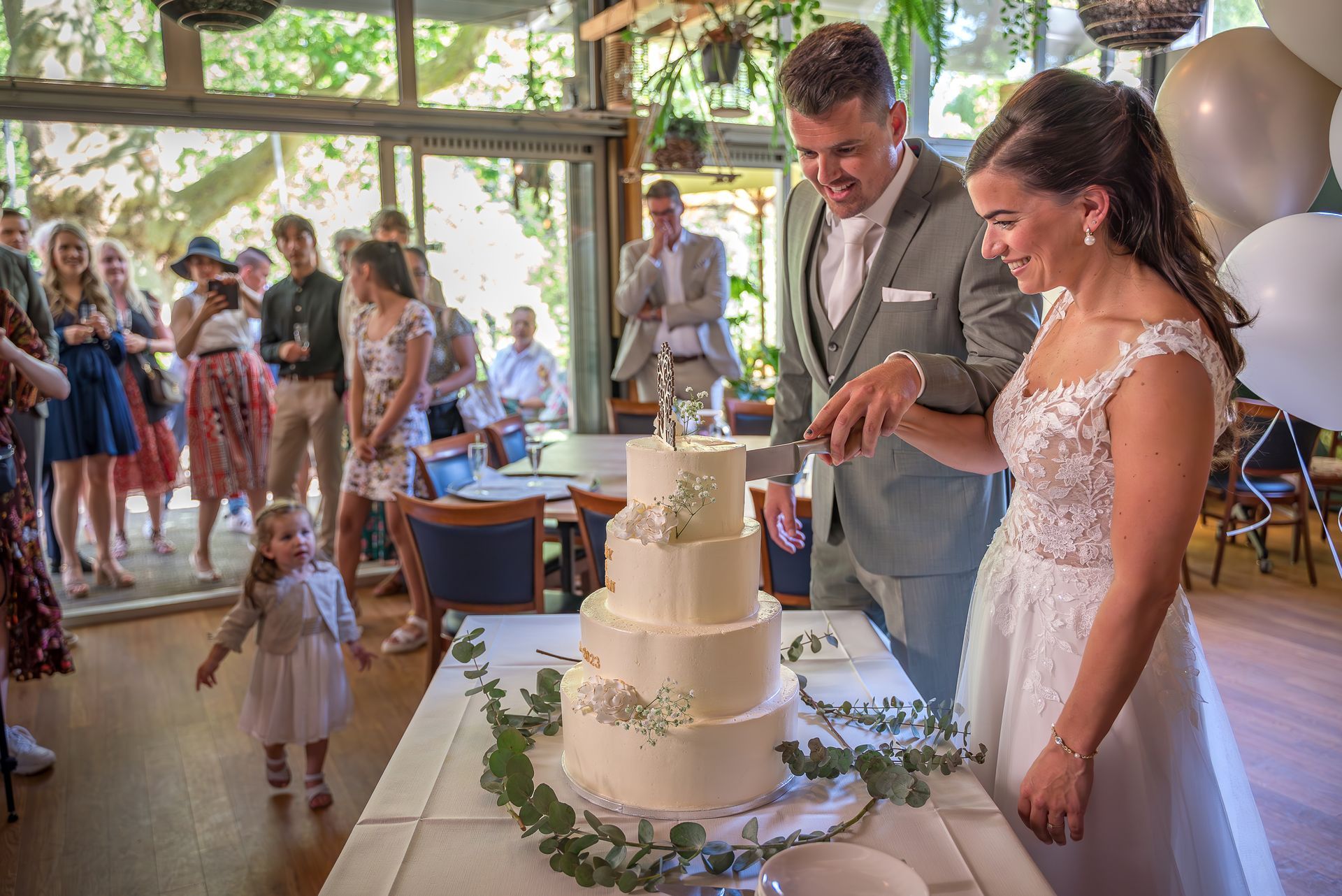 Een bruid en bruidegom snijden hun bruidstaart aan.