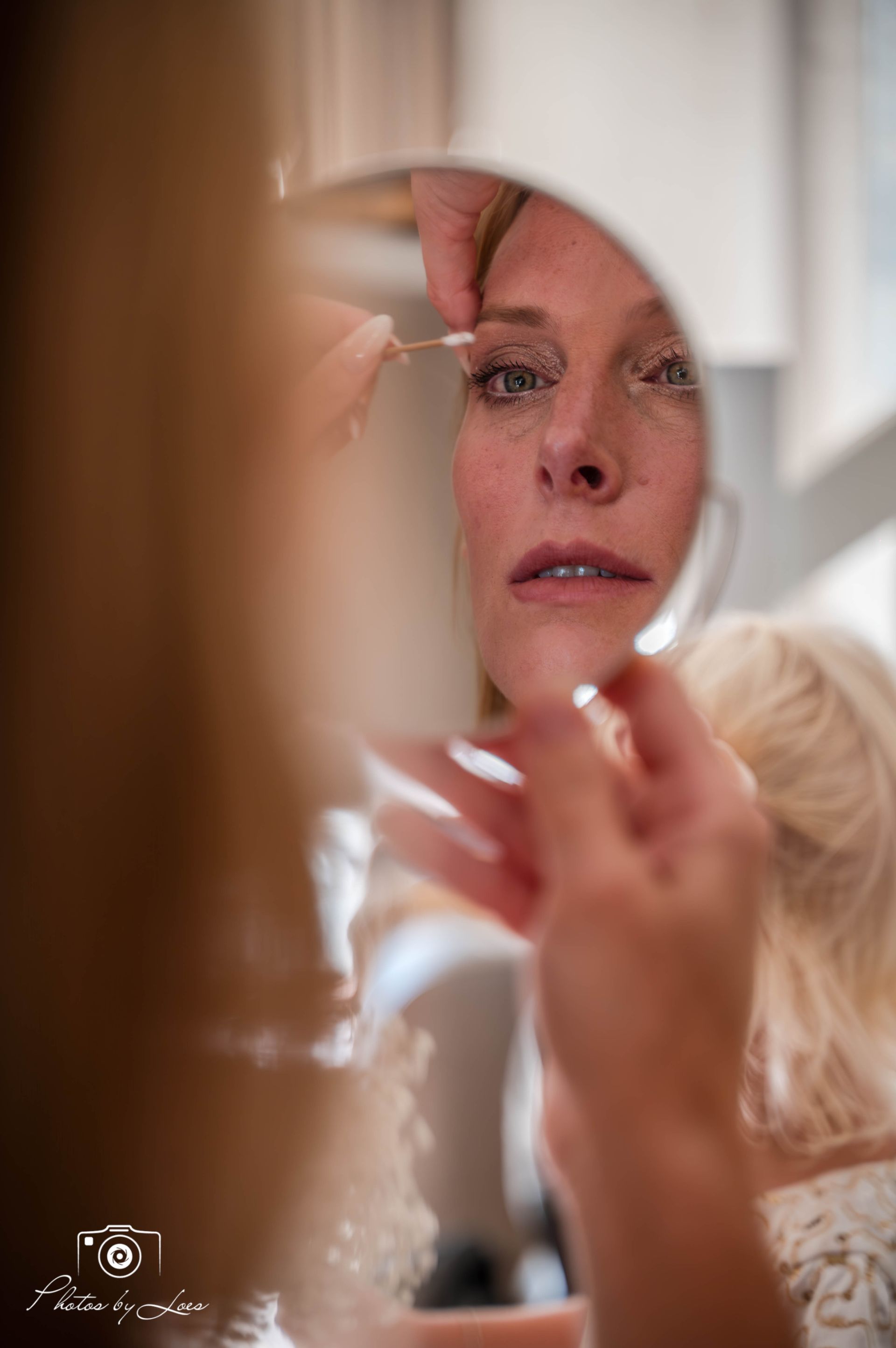 Een vrouw brengt make-up aan voor de spiegel.