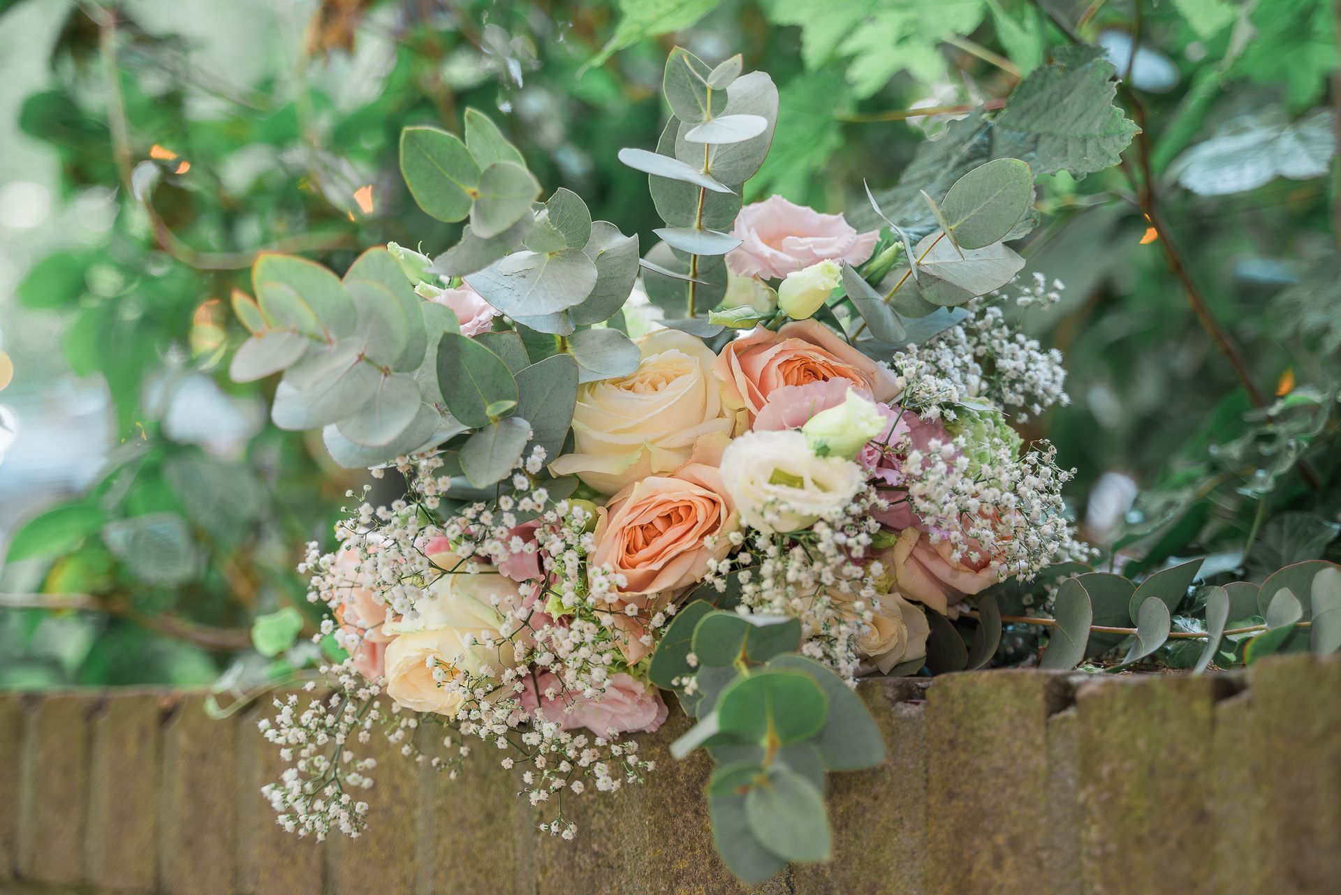 Een boeket bloemen bovenop een houten hek.