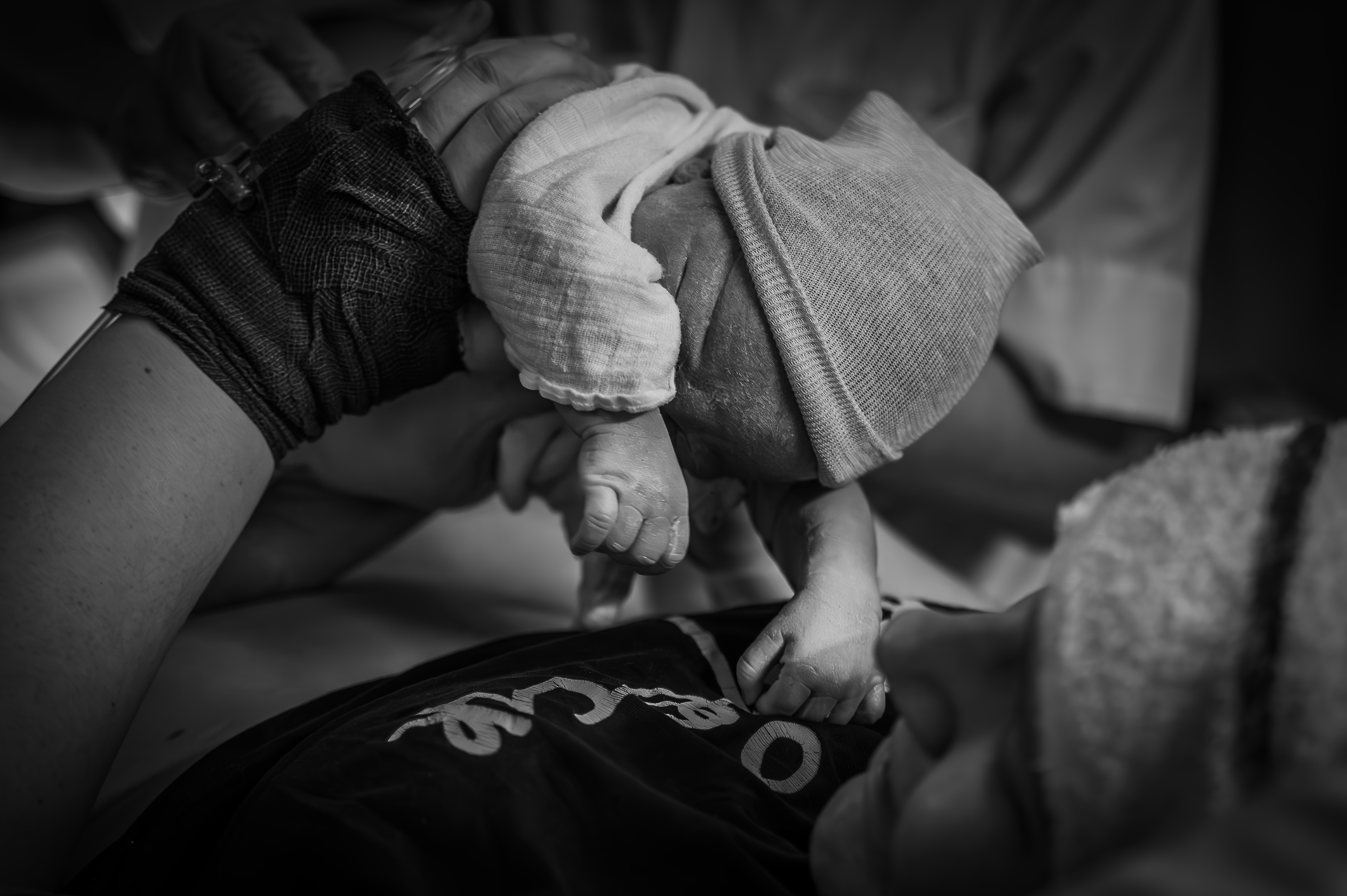 Een zwart-witfoto van een vrouw die een pasgeboren baby vasthoudt.