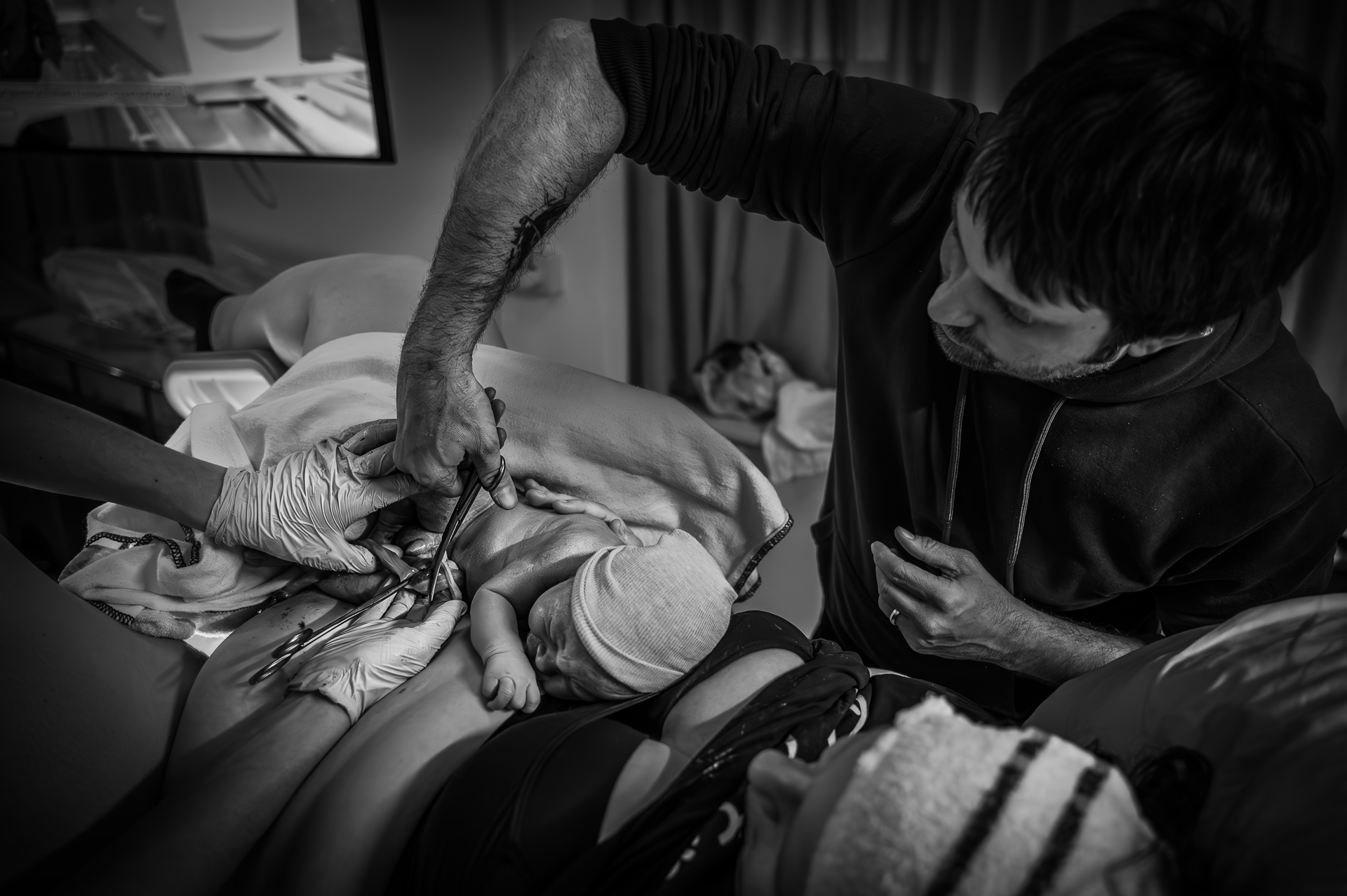 Een zwart-witfoto van een man die een pasgeboren baby vasthoudt.