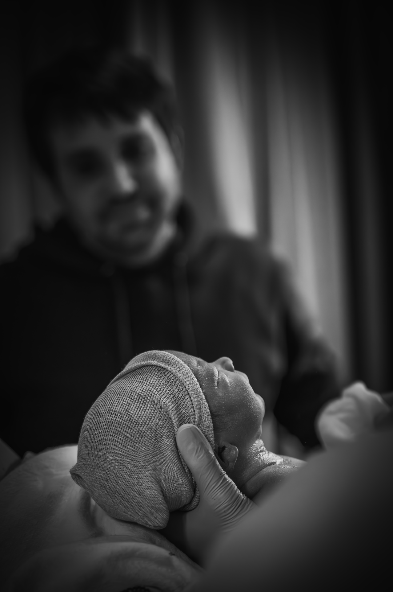 Op een zwart-witfoto houdt een man een baby in zijn armen.