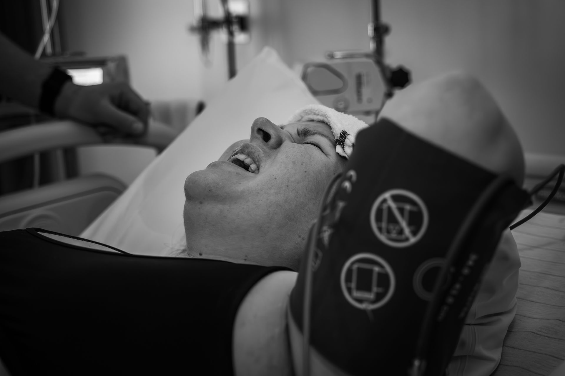 Een man ligt in een ziekenhuisbed met een verband om zijn arm.