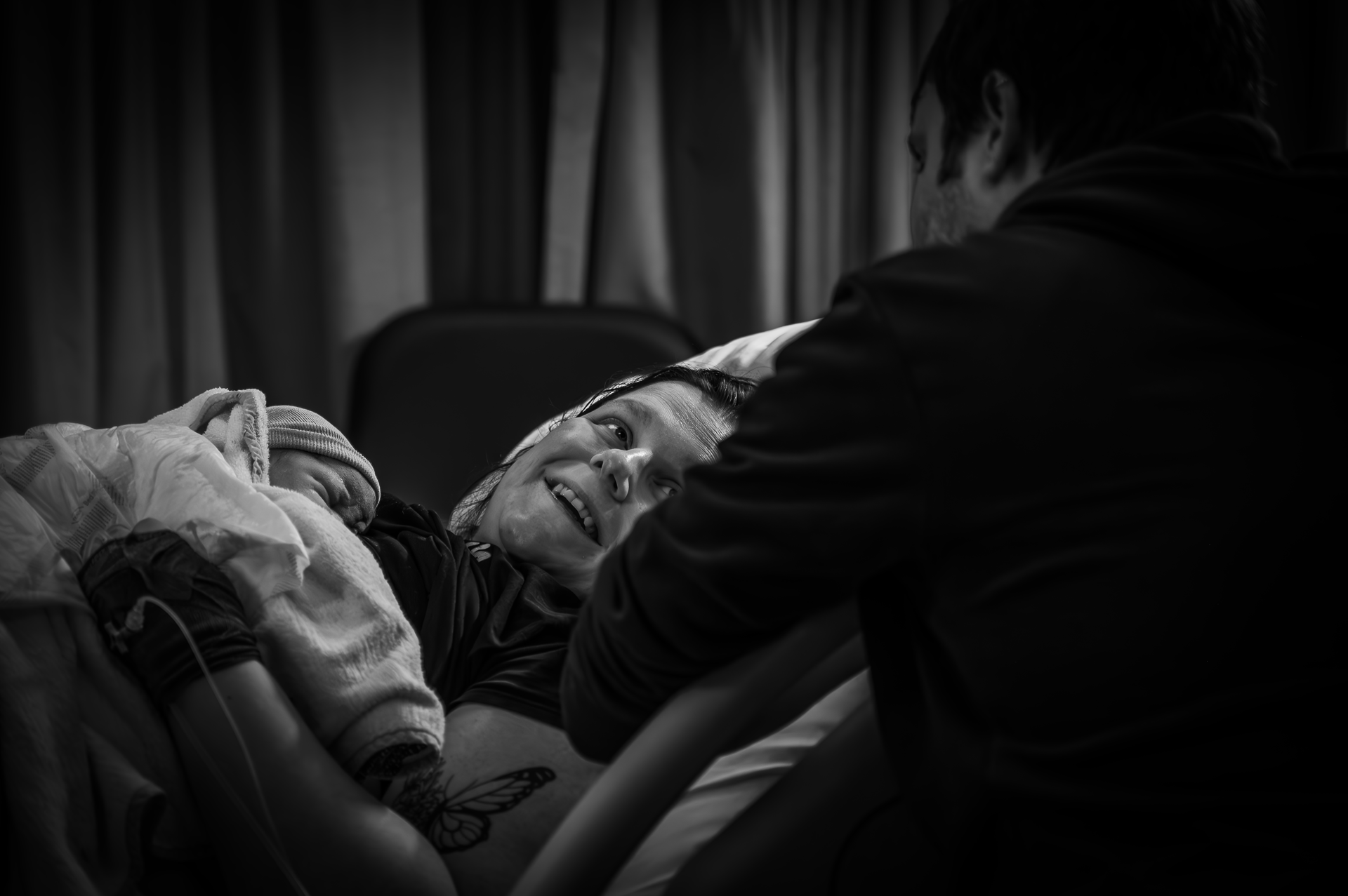 Een zwart-witfoto van een man die een pasgeboren baby vasthoudt.