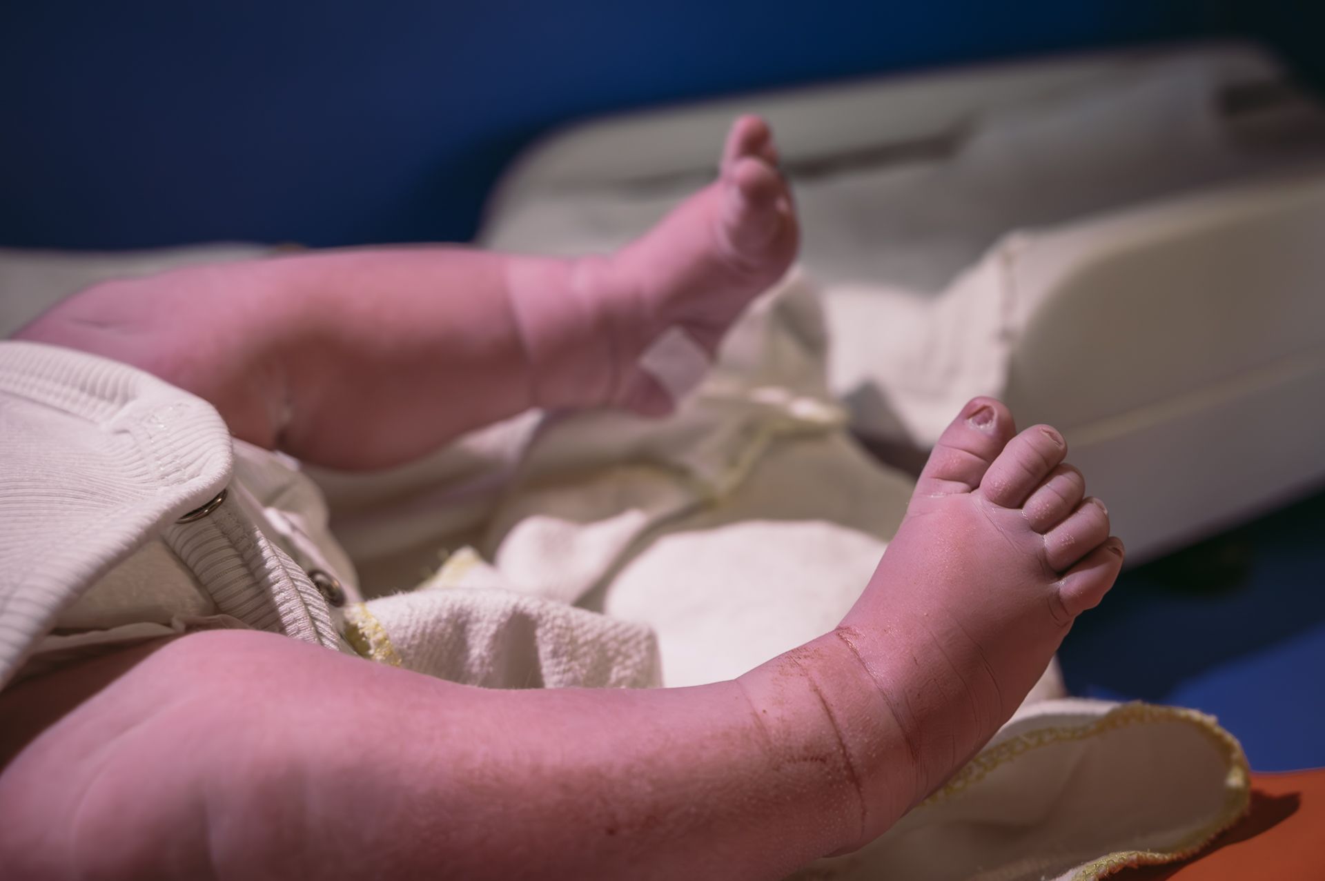 Een close-up van de voeten van een baby op een verschoontafel.