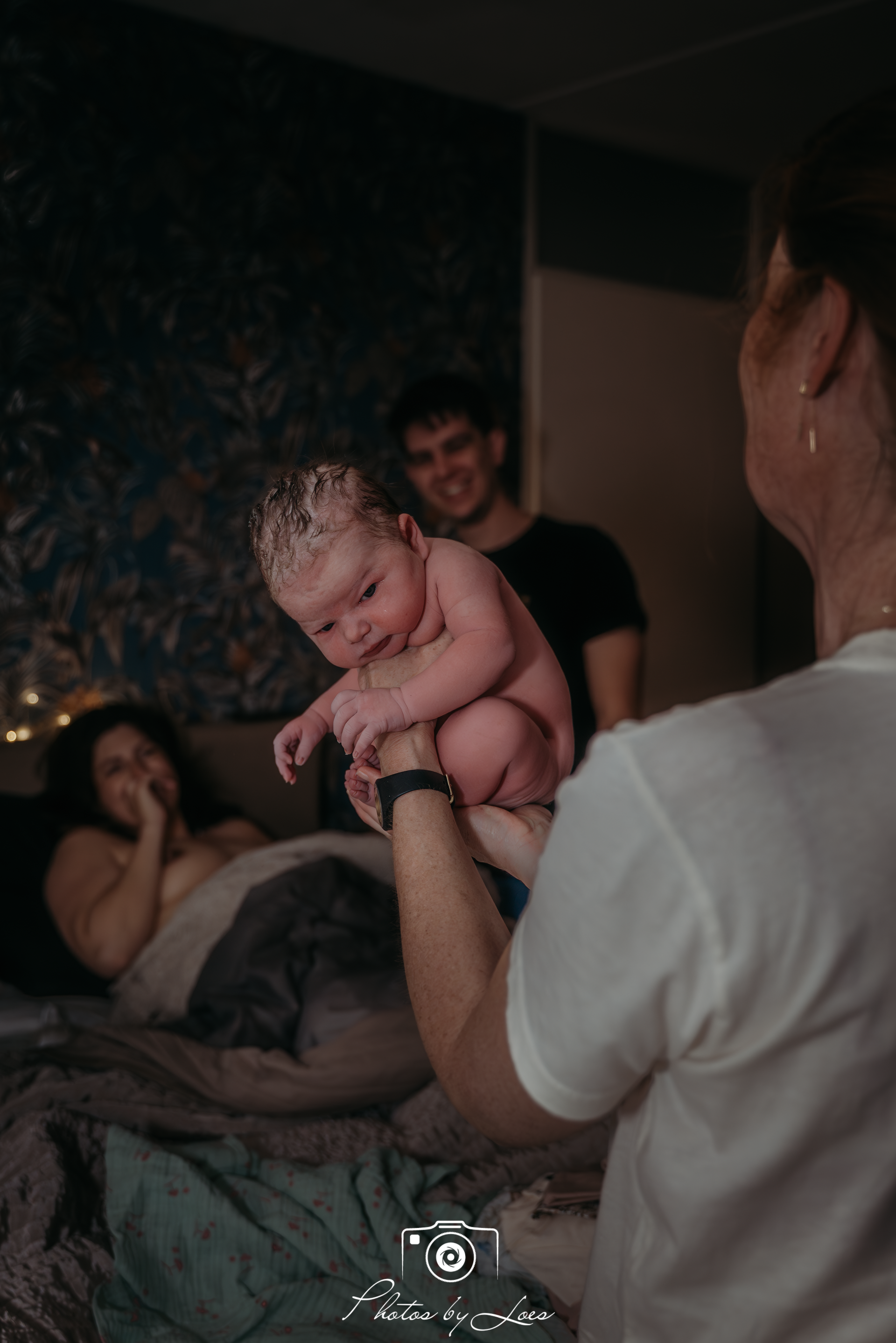 Verloskundige showt de pasgeboren baby aan de ouders