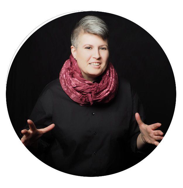 Photo of Carrie E Neal - wearing a black shirt and a pink scarf, on a black background