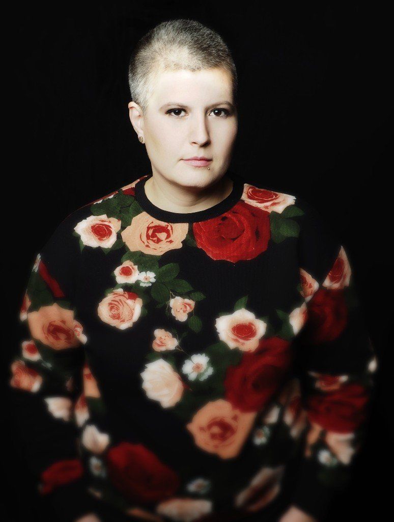 A photo of Carrie E Neal - black background and wearing a floral sweater