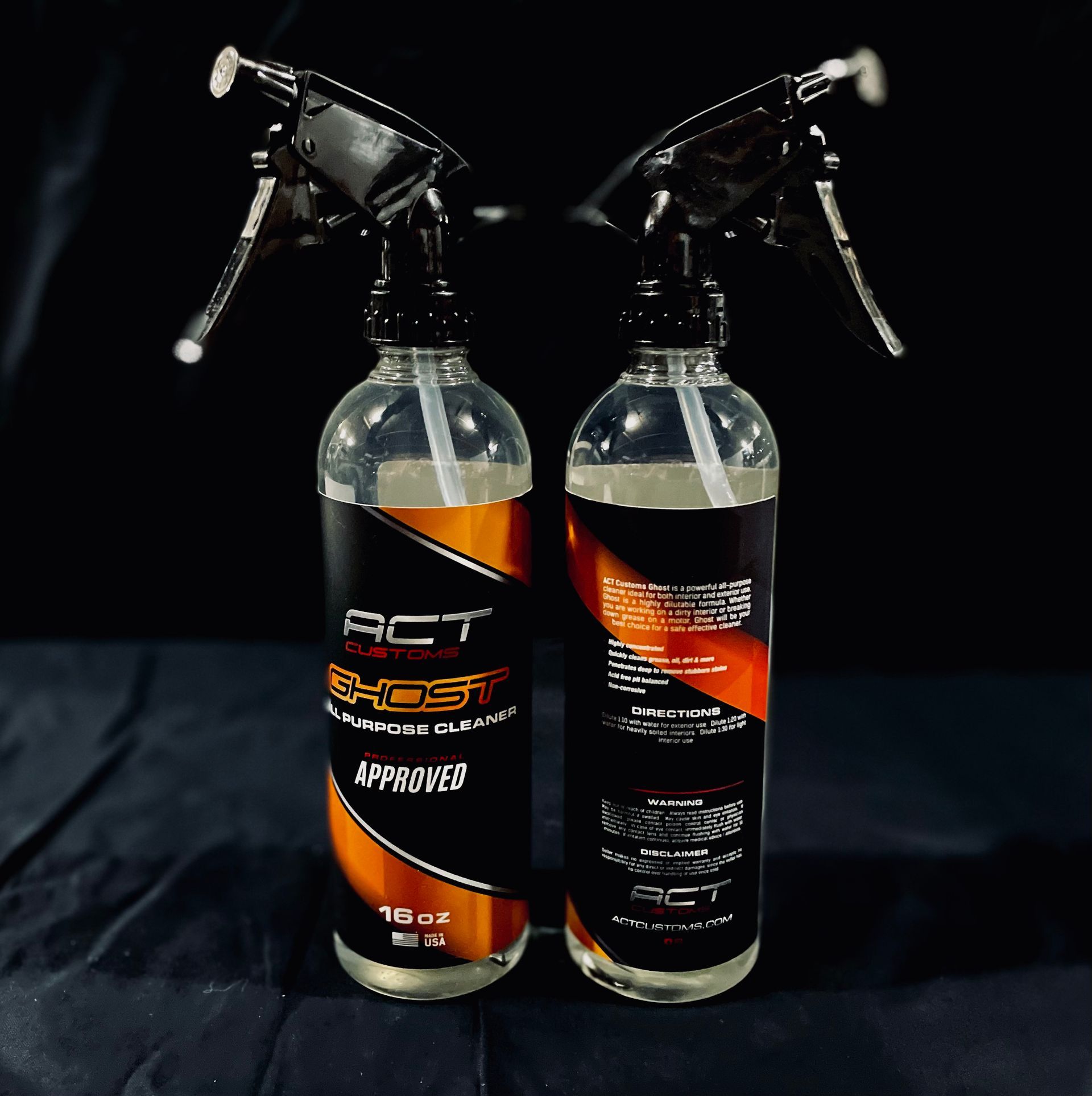 Two spray bottles are sitting next to each other on a table.