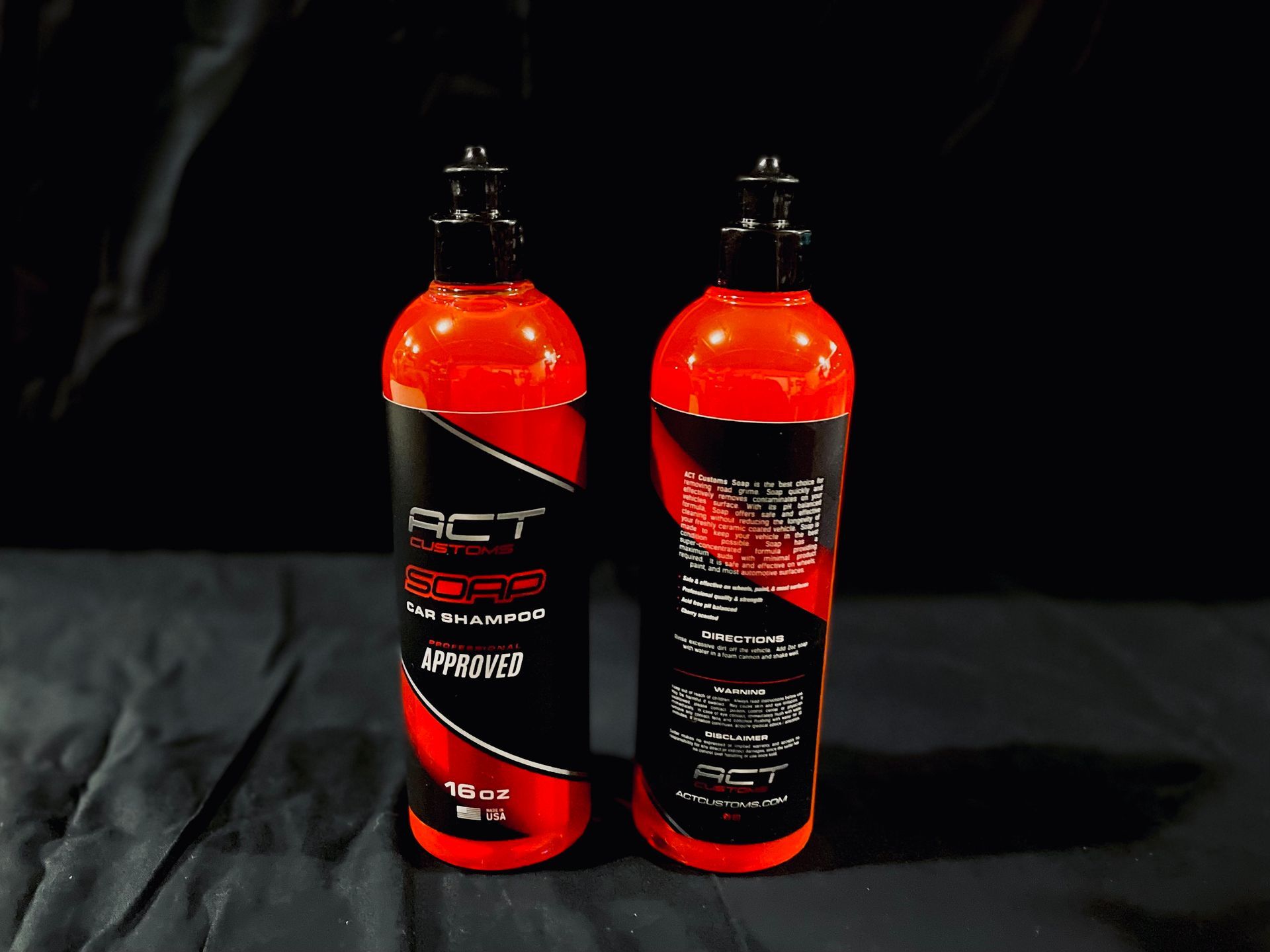 Two bottles of red liquid are sitting next to each other on a table.