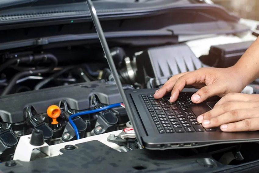 A Person is Working on a Laptop Computer Under the Hood of a Car — Toowoomba Lube & Mechanical in Glenvale, QLD