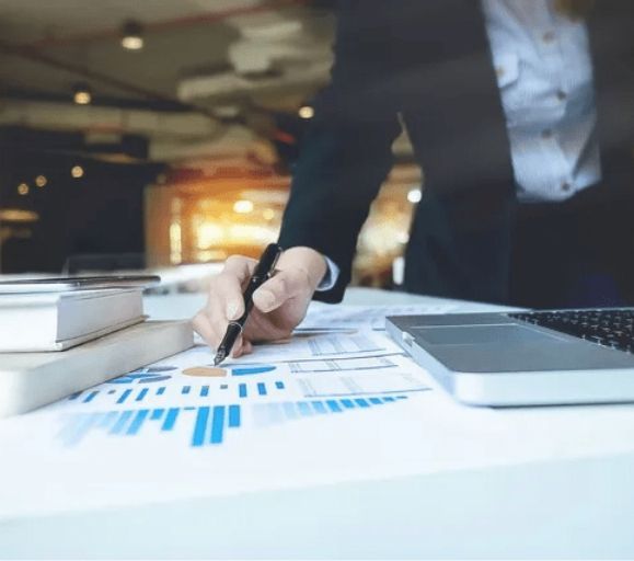 A person is writing on a piece of paper with a pen.