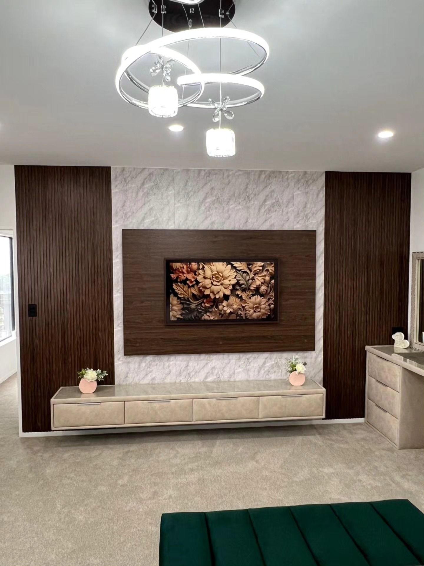 Modern bedroom with floating TV, gray rug, and decorative lighting.