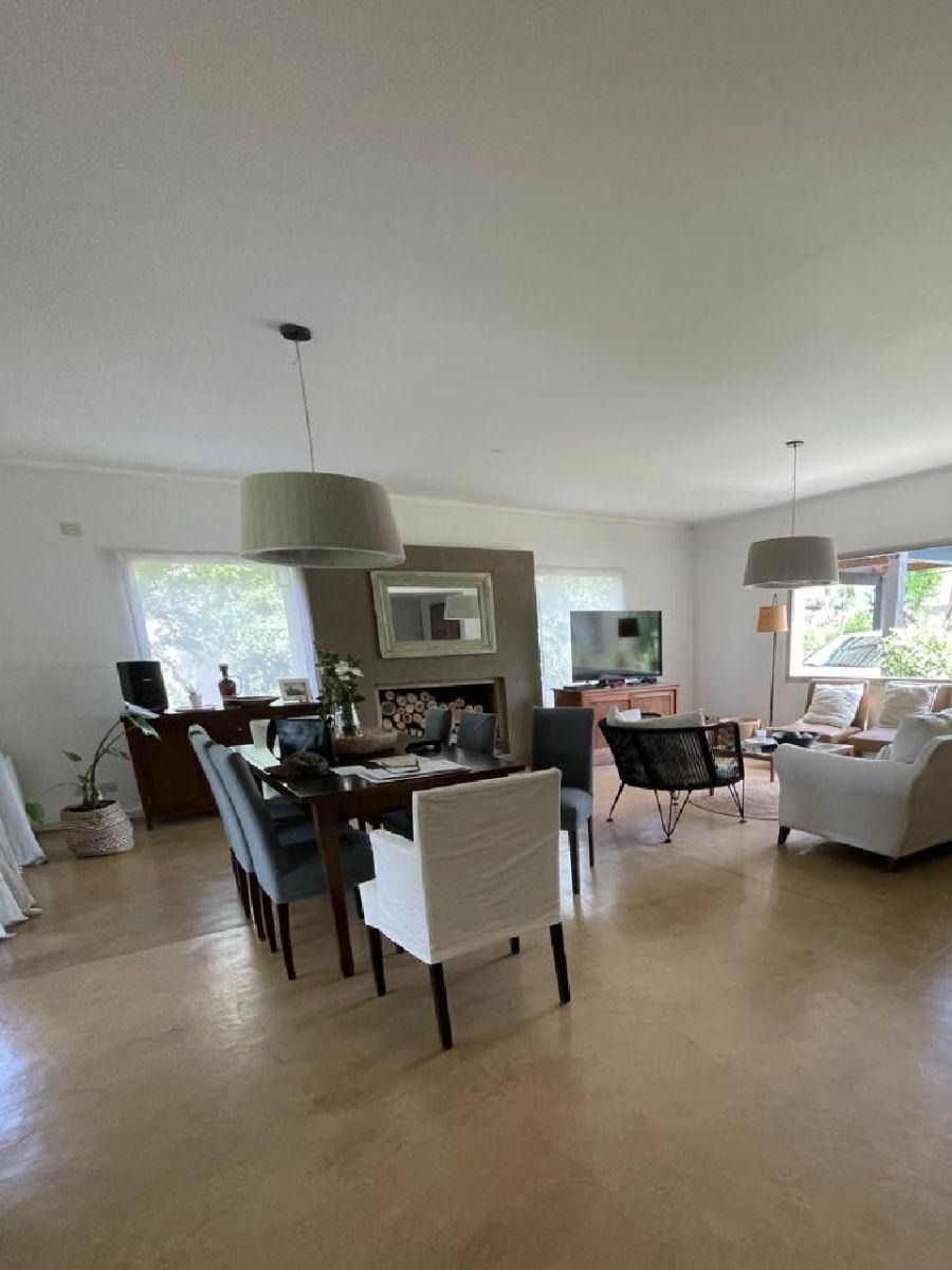 Amplio salón-comedor con mesa puesta, chimenea y sofá.