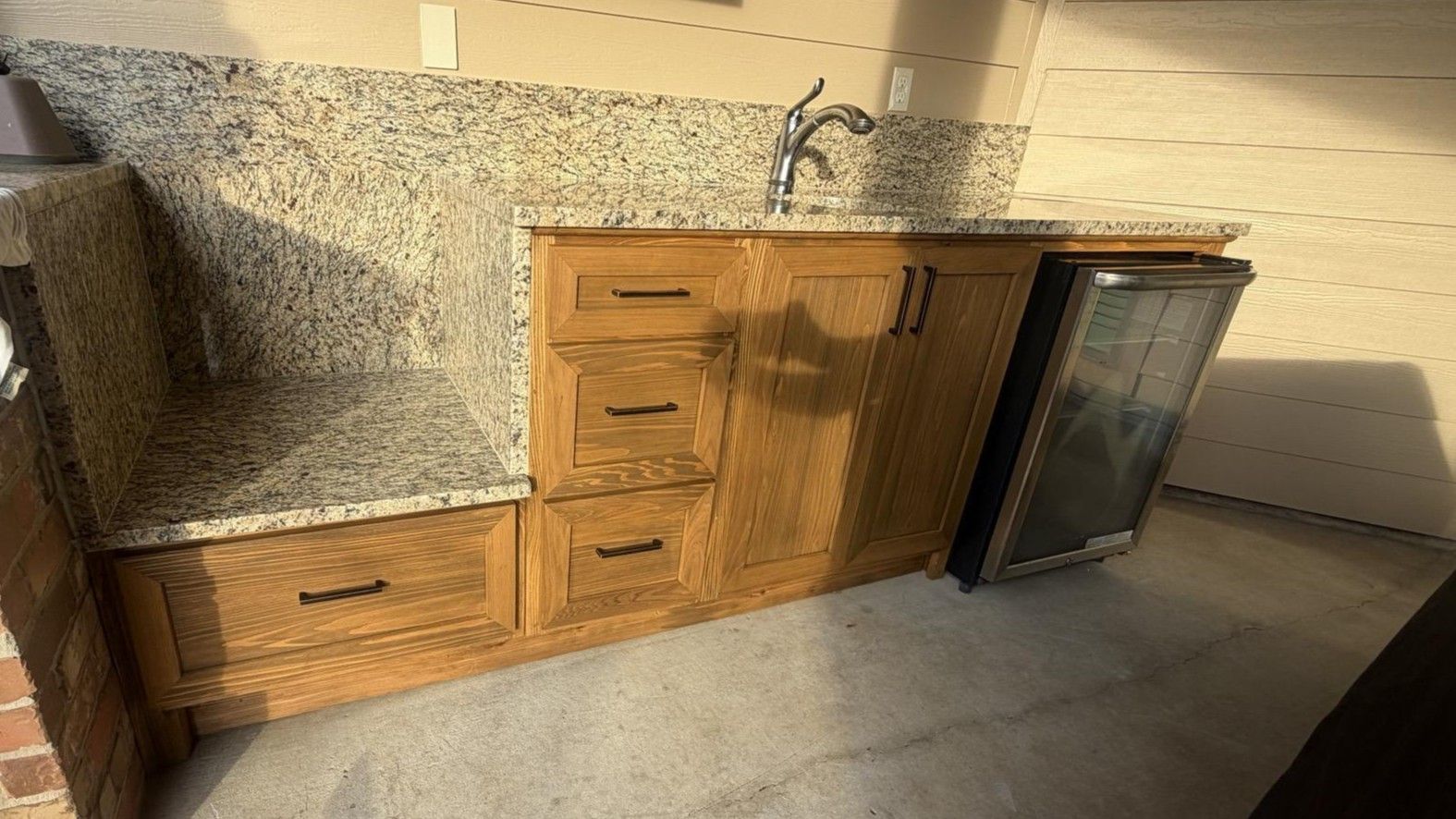 Patterned kitchen backsplash and speckled granite countertop beneath a slanted wall.