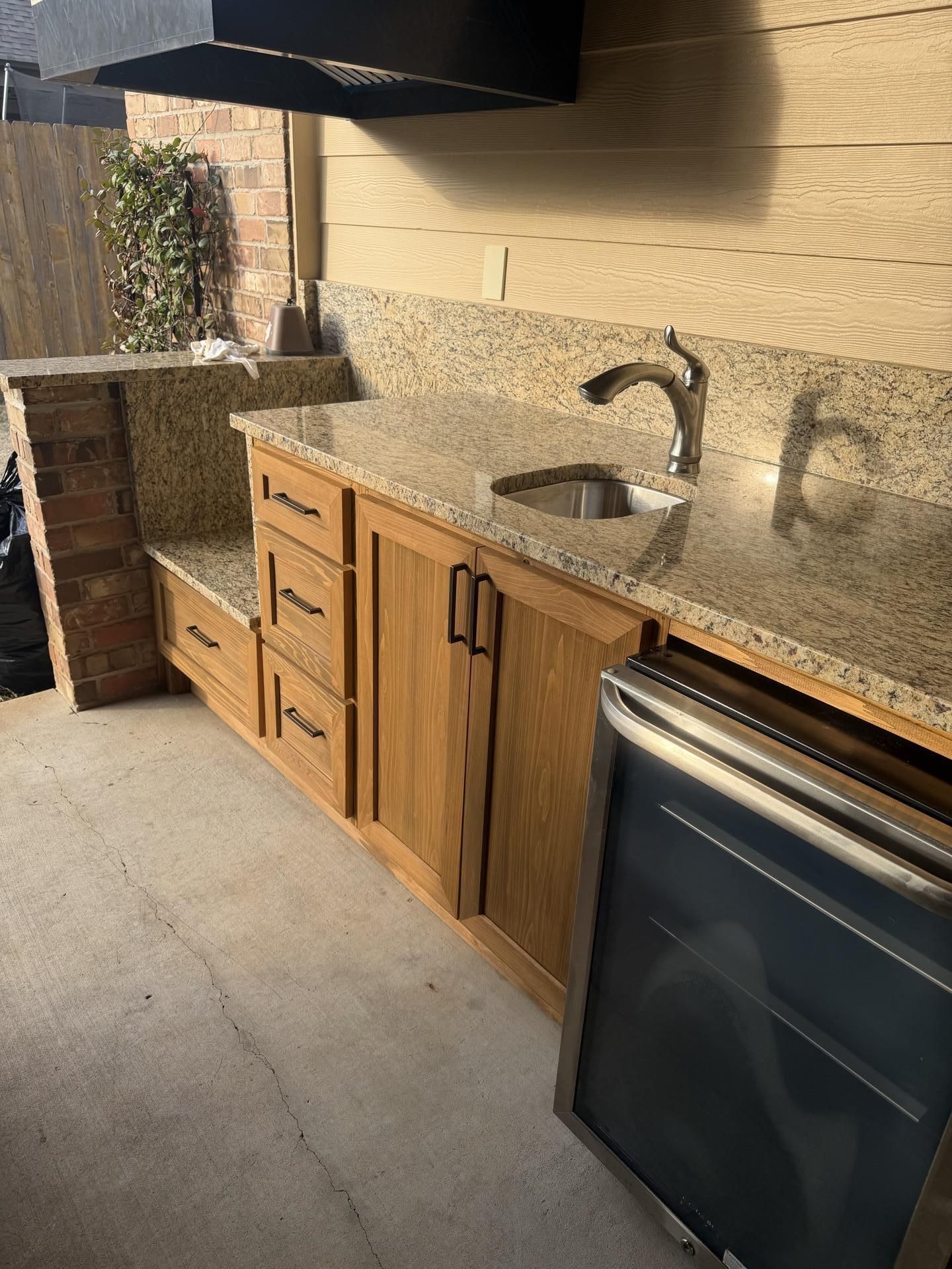Patterned kitchen backsplash and speckled granite countertop beneath a slanted wall.