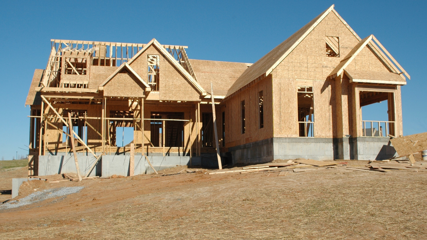Veteran family standing in front of a new home under construction in Tacoma, Washington, with a VA c
