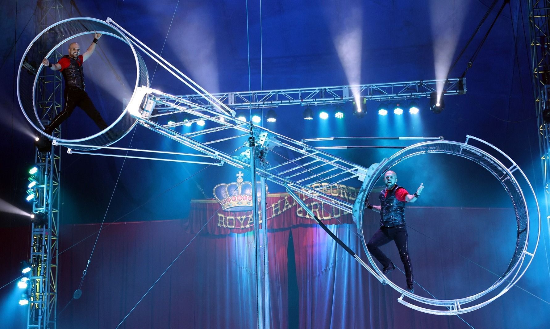 Two men are performing a stunt in a circus arena | Arabia Shrine Circus