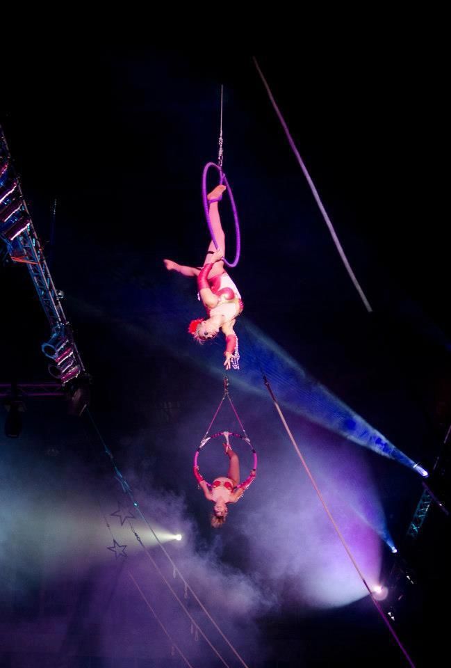 Two aerial performers are hanging from a rope in a circus. | Arabia Shrine Circus