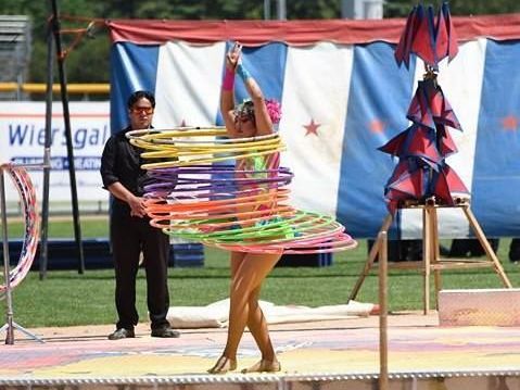 A woman is performing with hula hoops on a stage | Arabia Shrine Circus