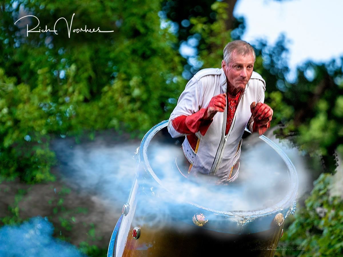 A man is sitting in a cauldron with smoke coming out of it. | Arabia Shrine Circus