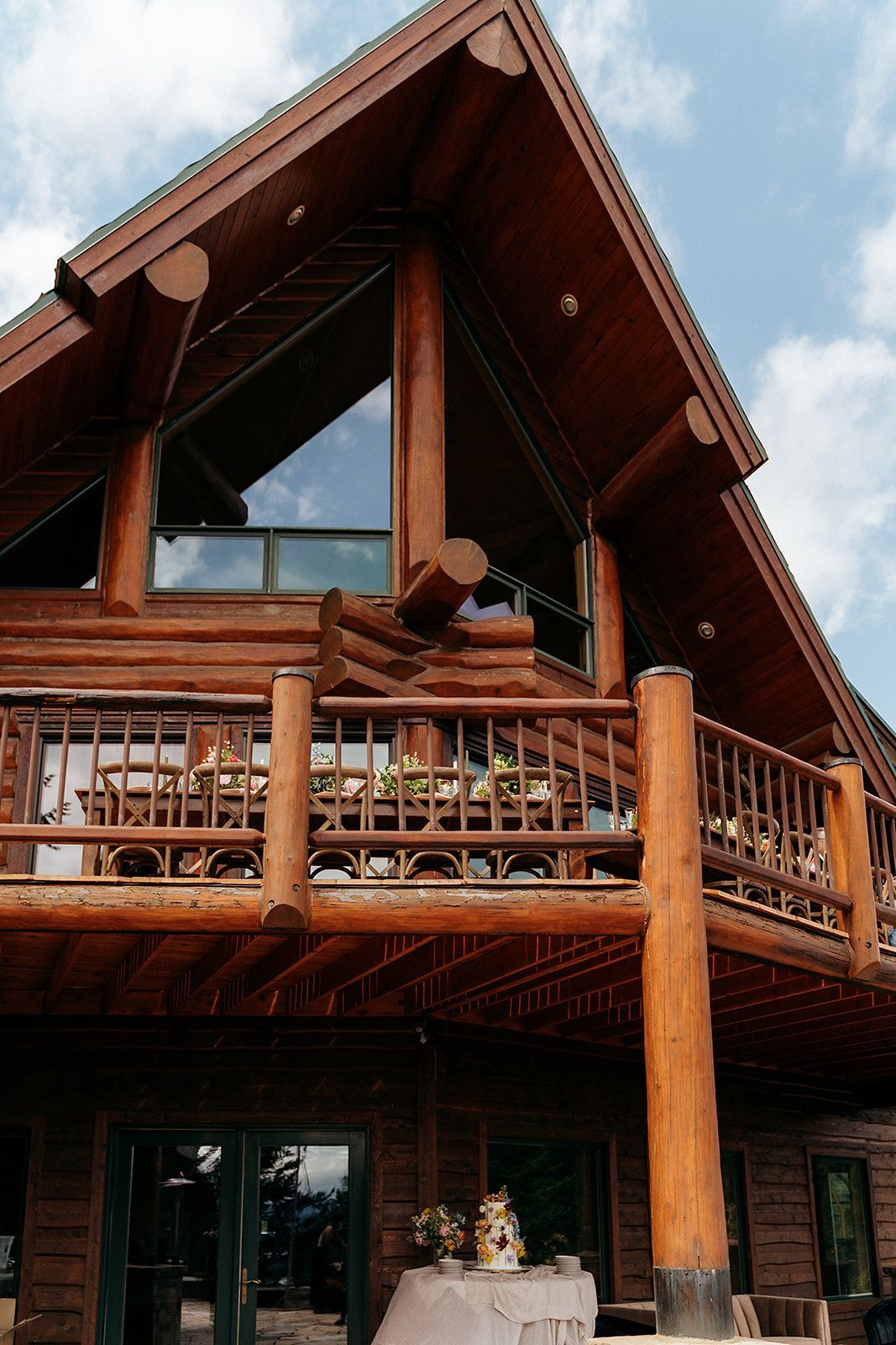 A large log cabin with a balcony and stairs.