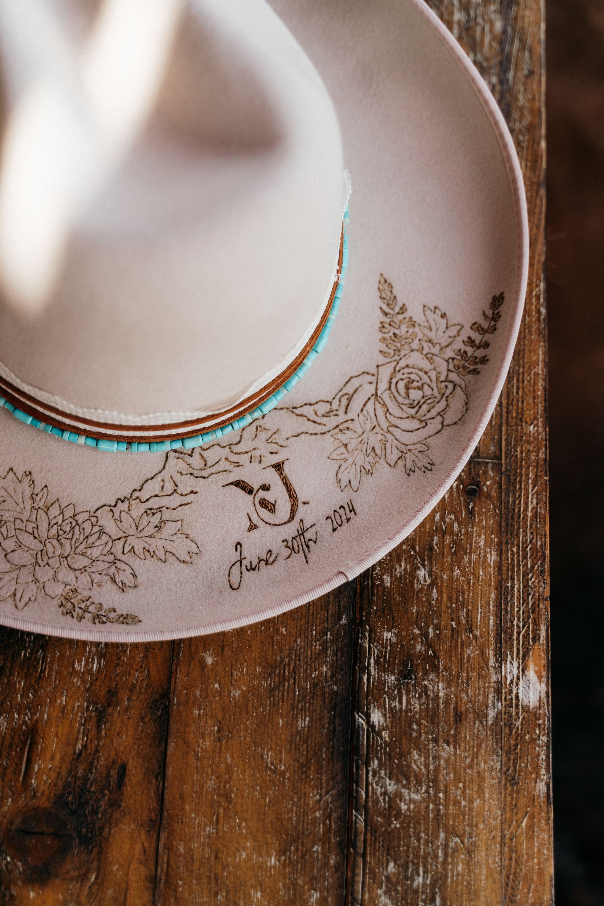A cowboy hat is sitting on top of a wooden table.