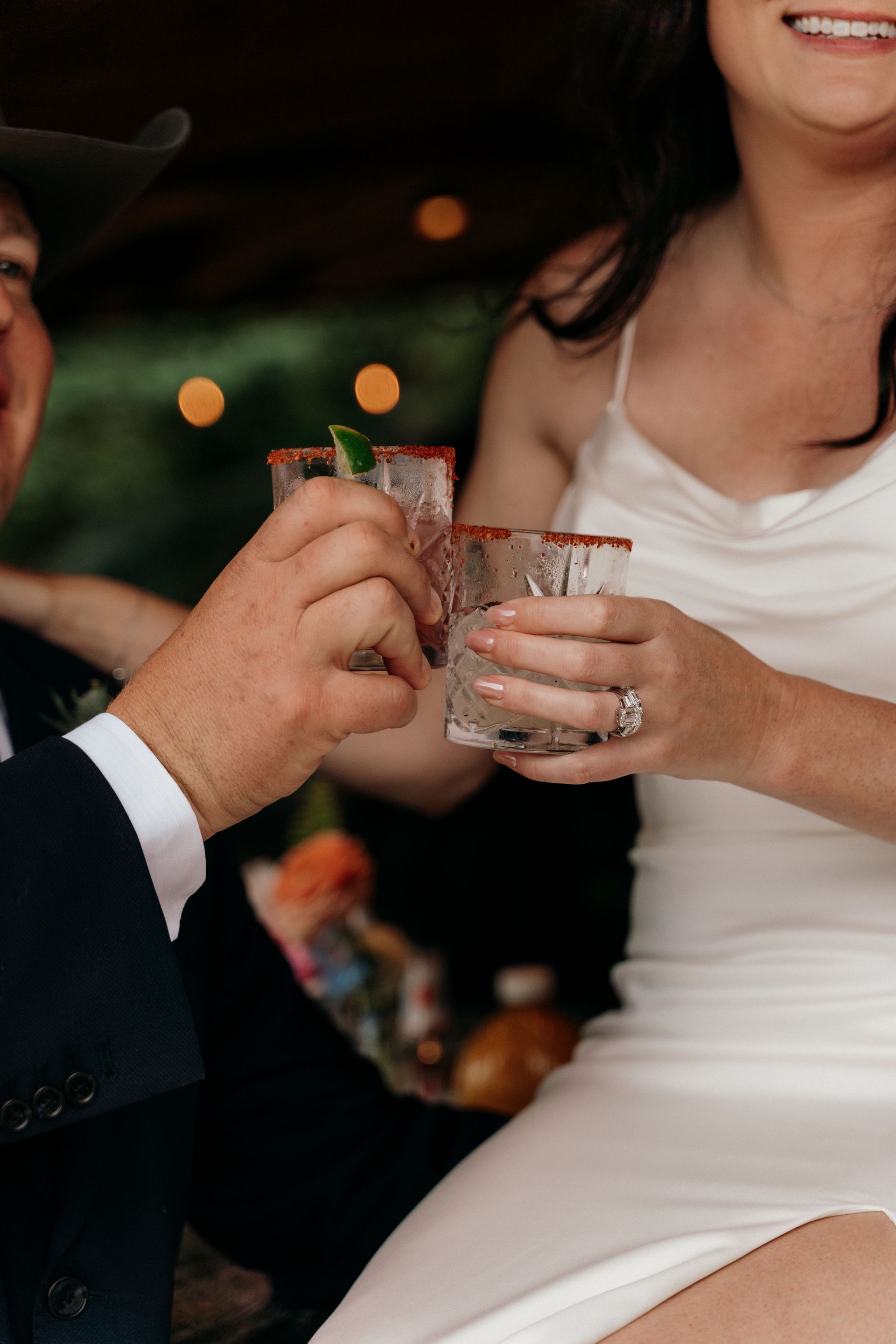 A bride and groom are toasting with glasses of tequila.