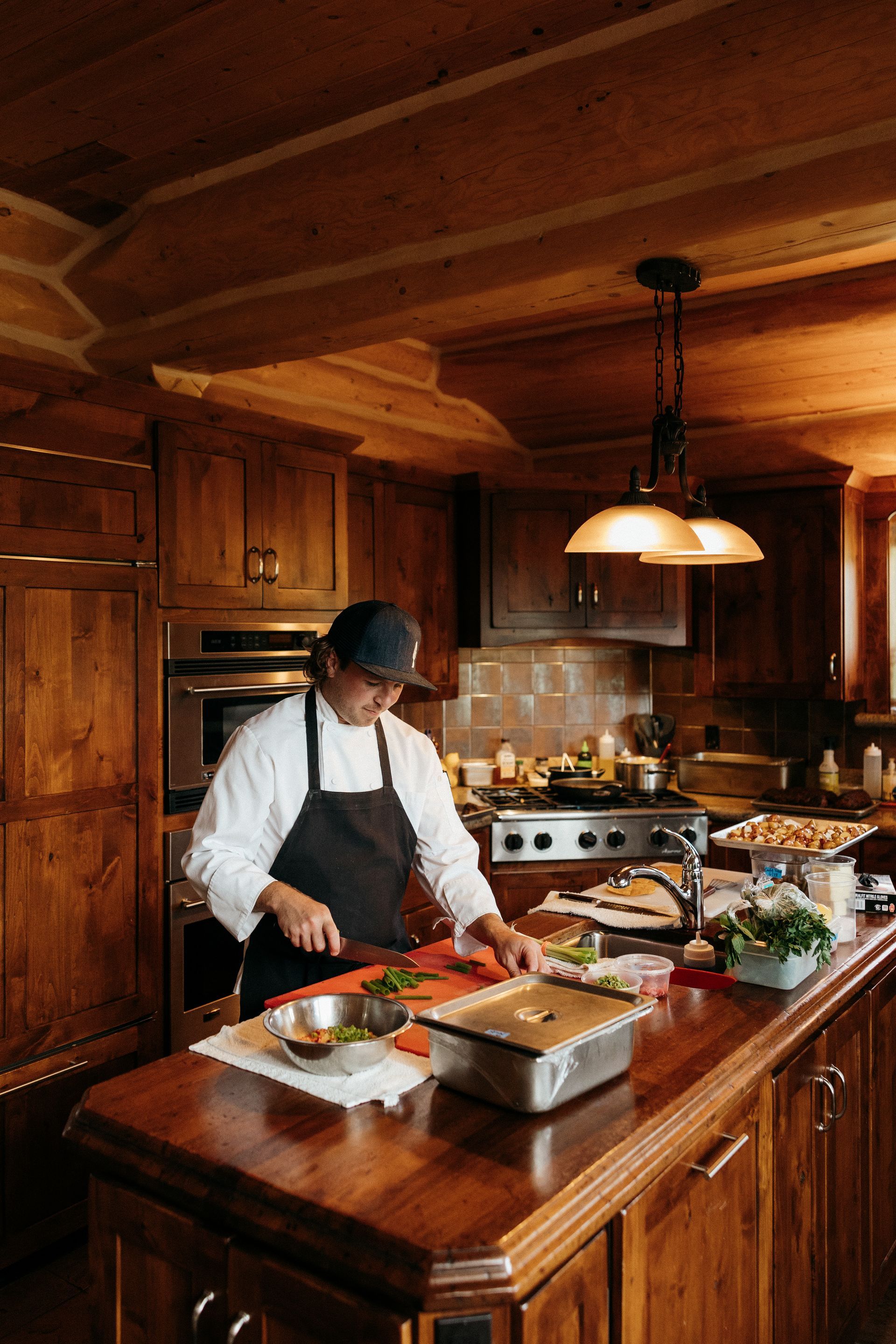 A chef is cutting vegetables on a cutting board in a kitchen.