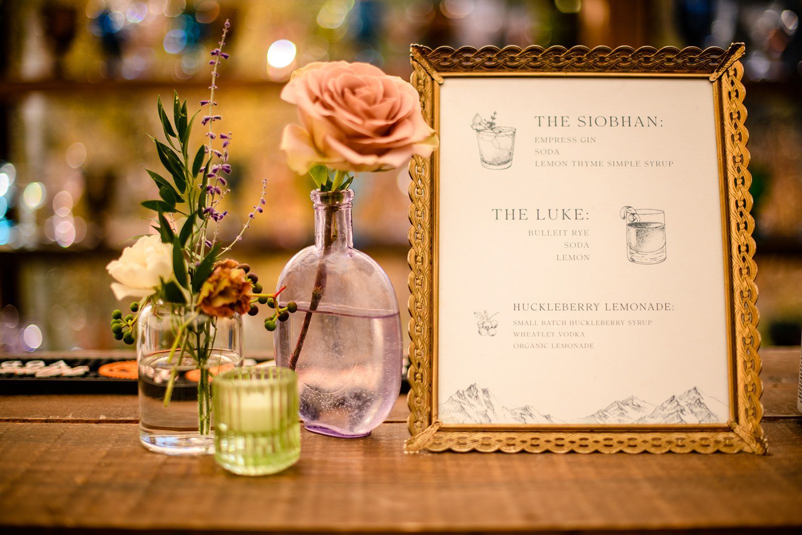 A framed menu is sitting on a wooden table next to a vase of flowers.