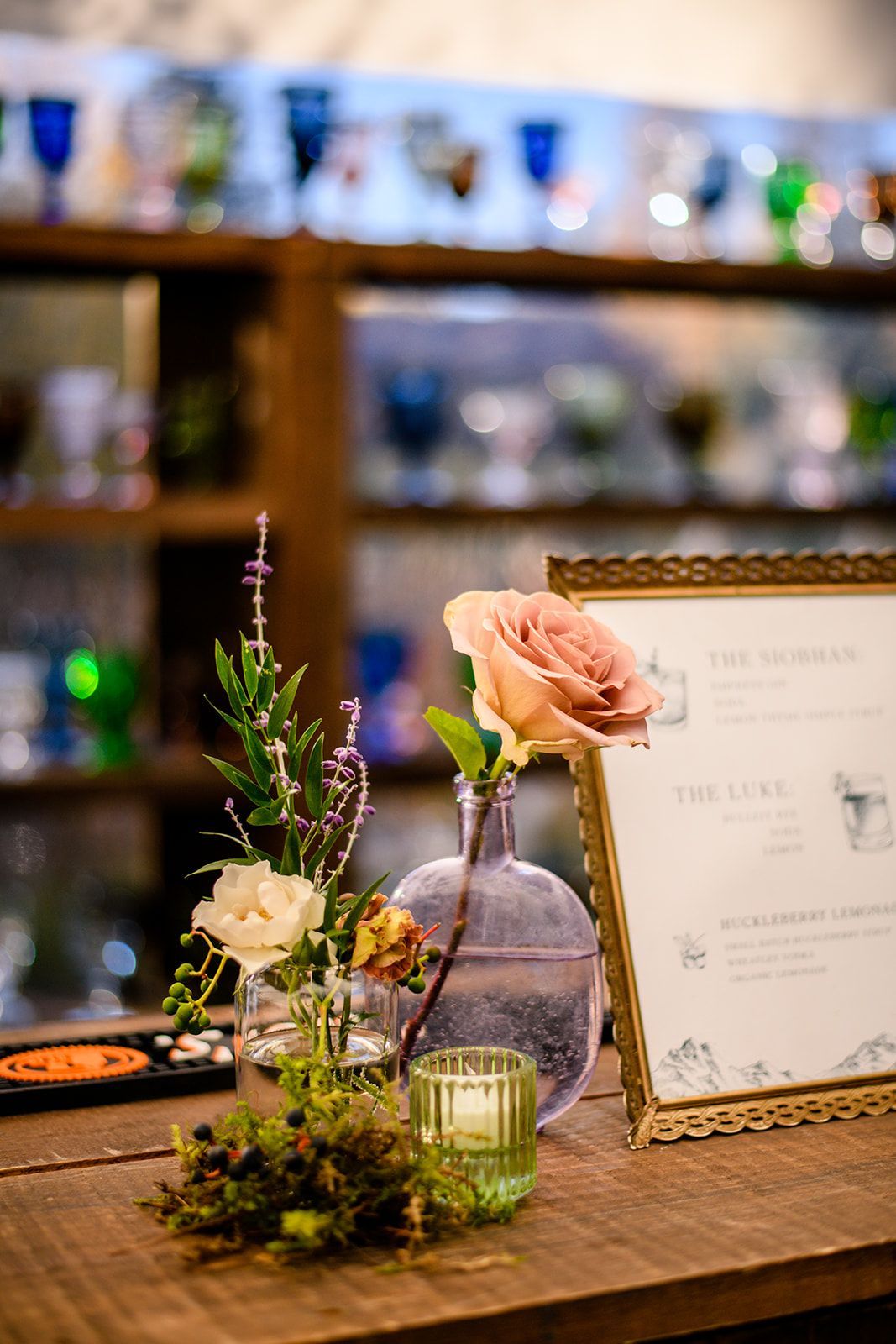 A table with a vase of flowers and a candle on it.
