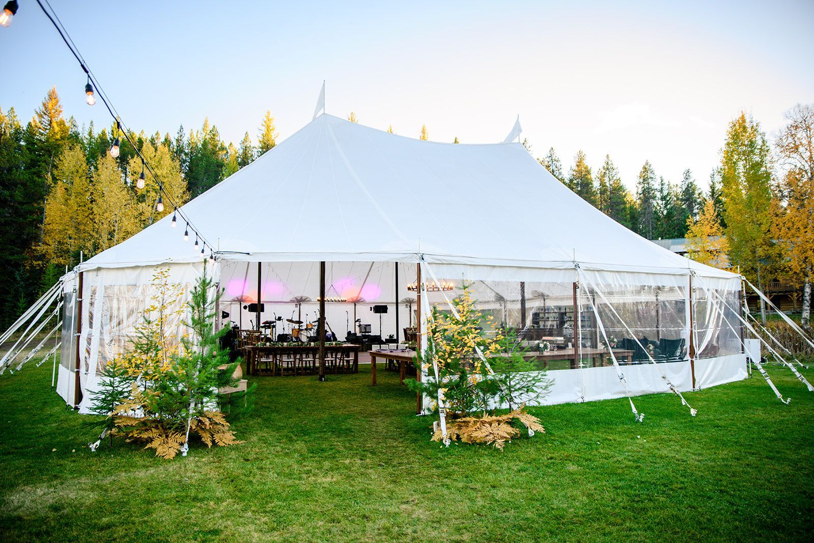 A large white tent is sitting in the middle of a grassy field.