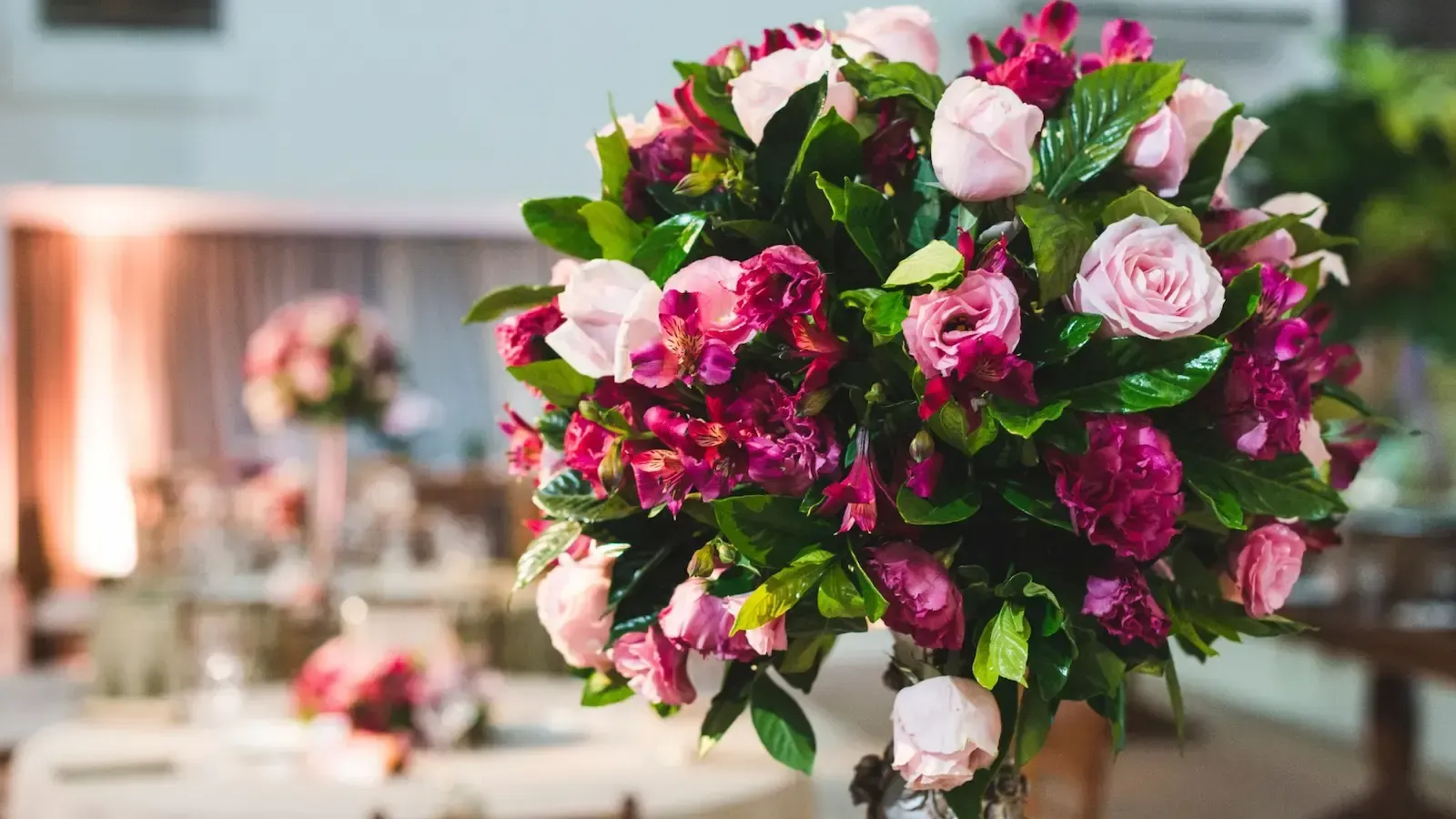 A vase filled with pink and purple flowers is sitting on a table.