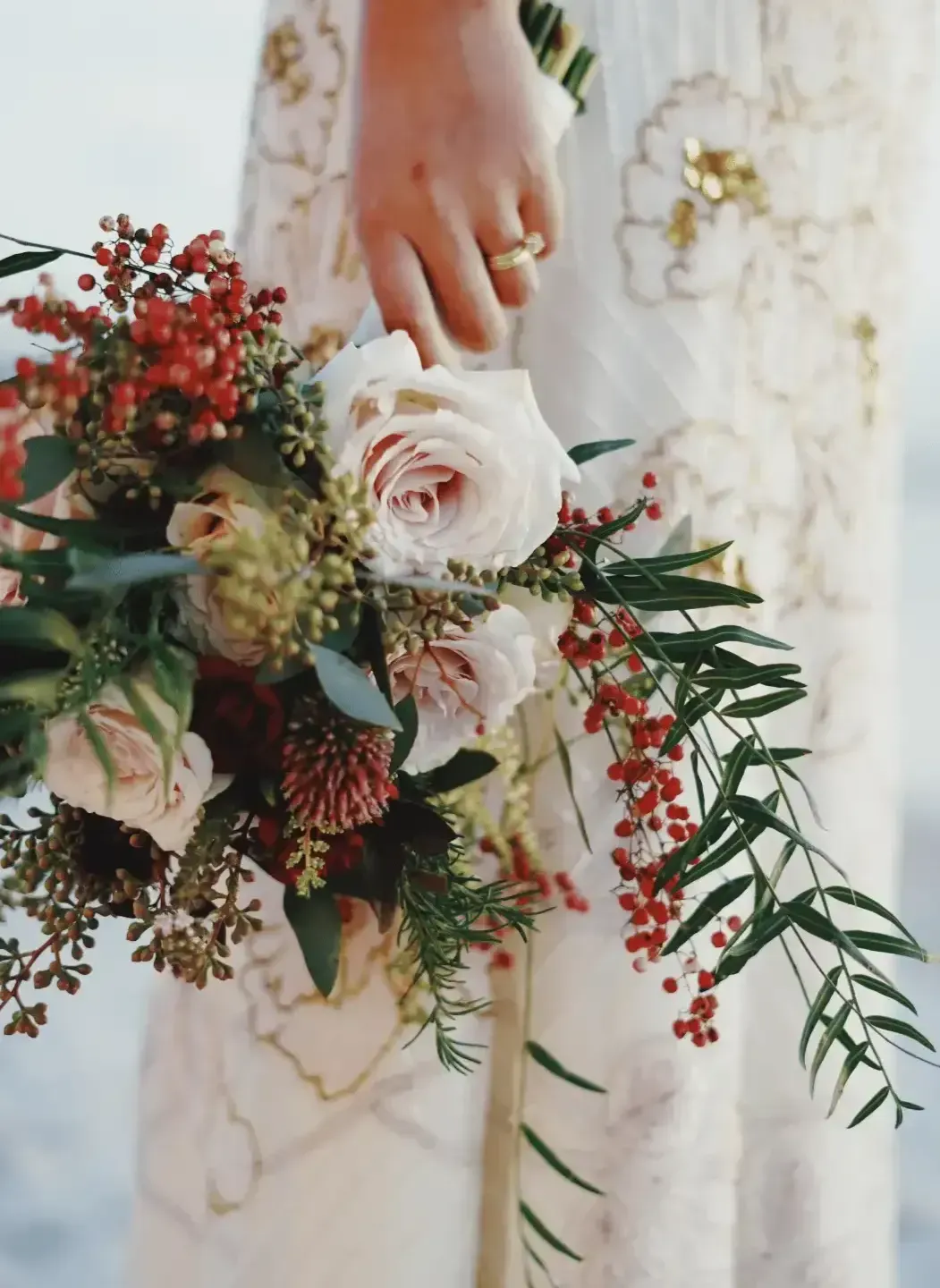 a woman in a white dress is holding a bouquet of flowers